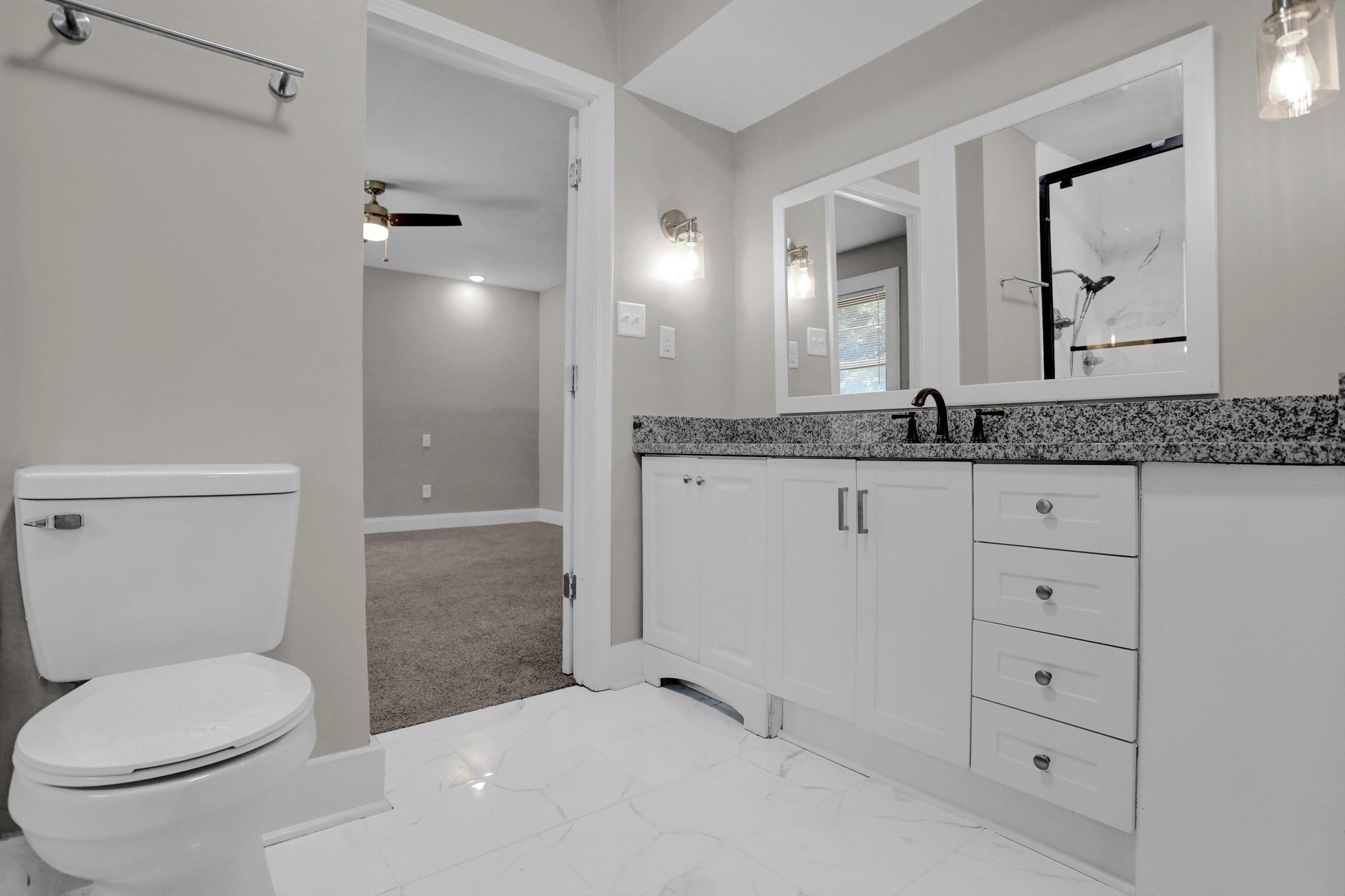 Bathroom featuring ceiling fan, toilet, tile patterned floors, and vanity