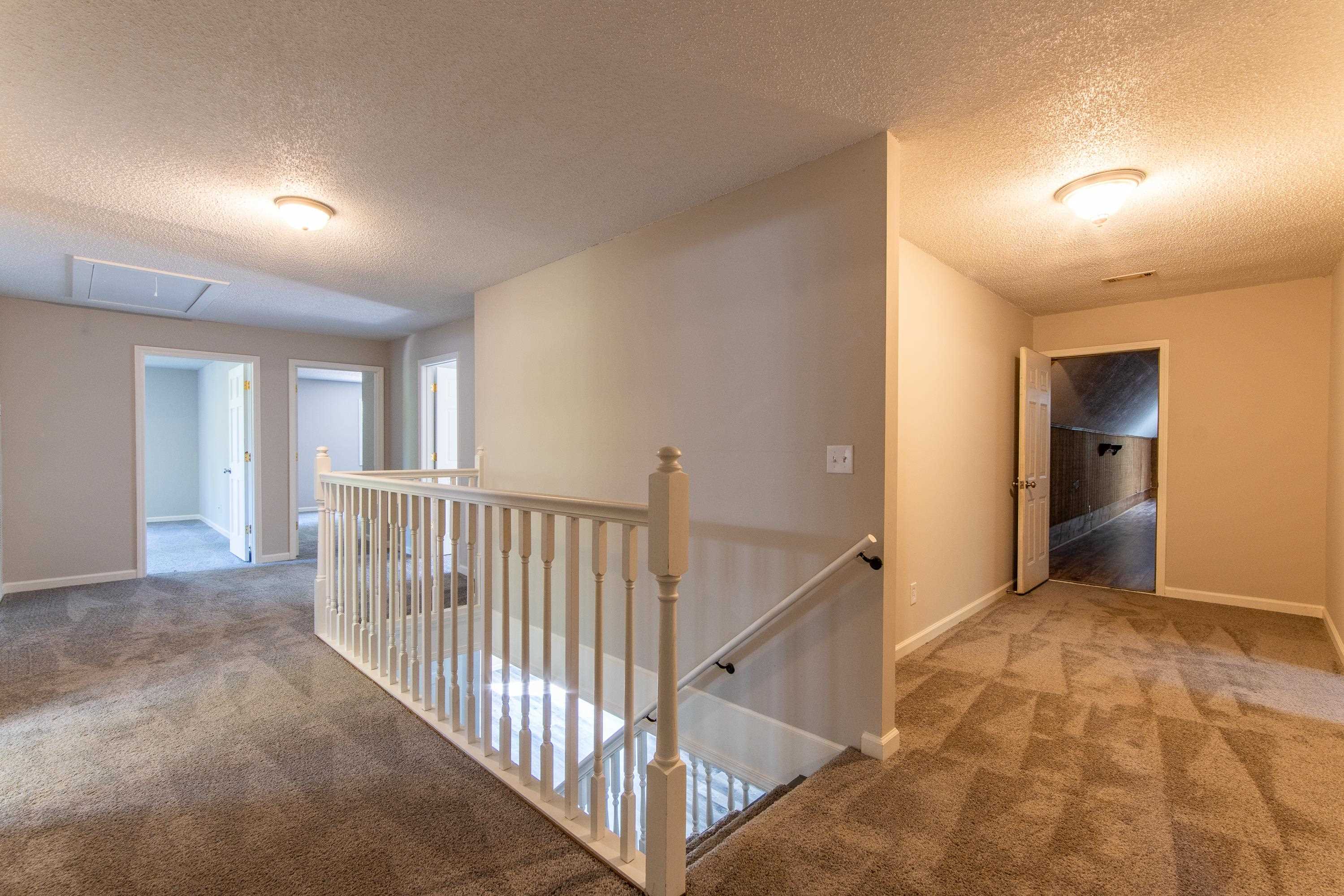 Hallway featuring a textured ceiling and carpet flooring