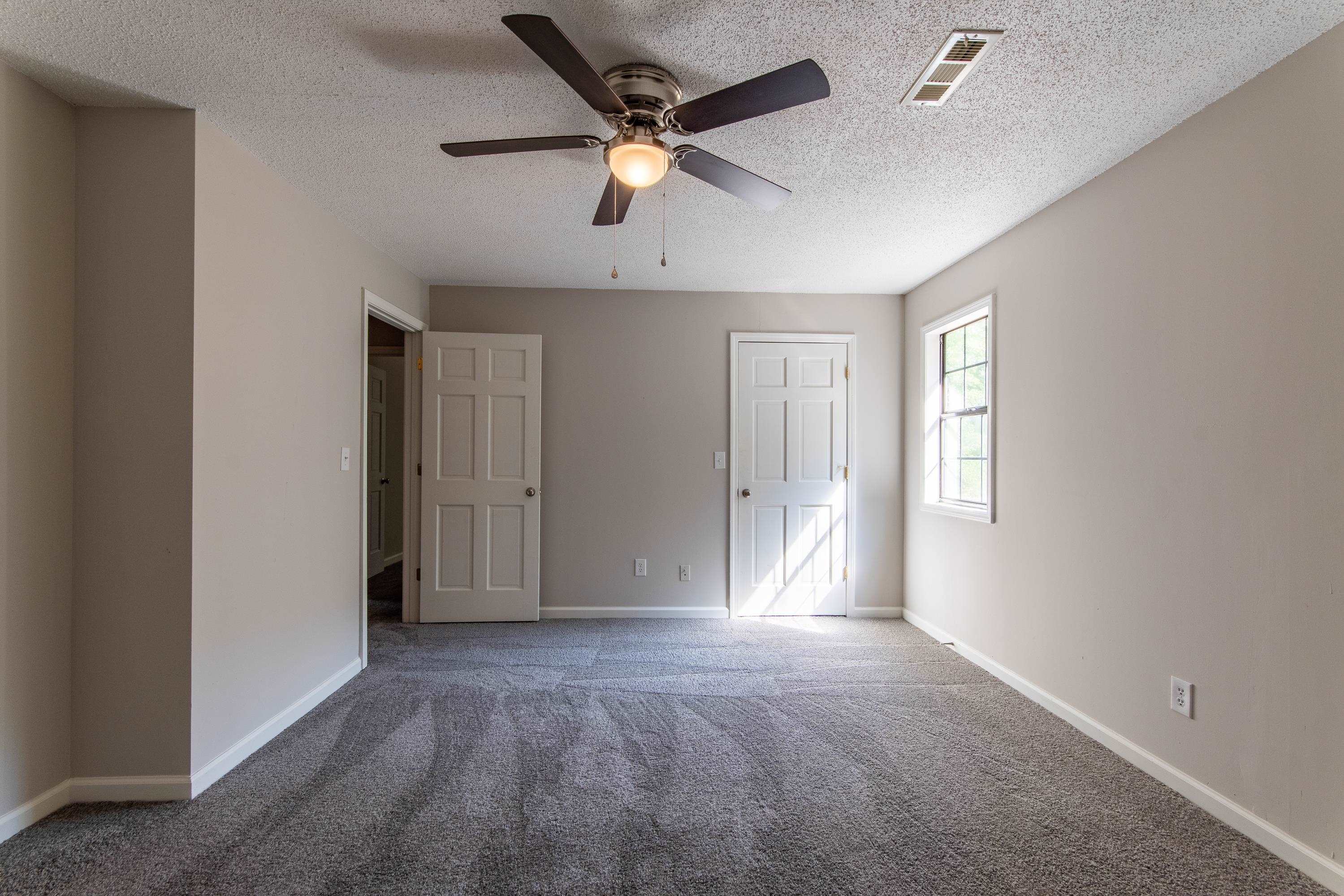 Unfurnished room featuring ceiling fan, a textured ceiling, and carpet floors