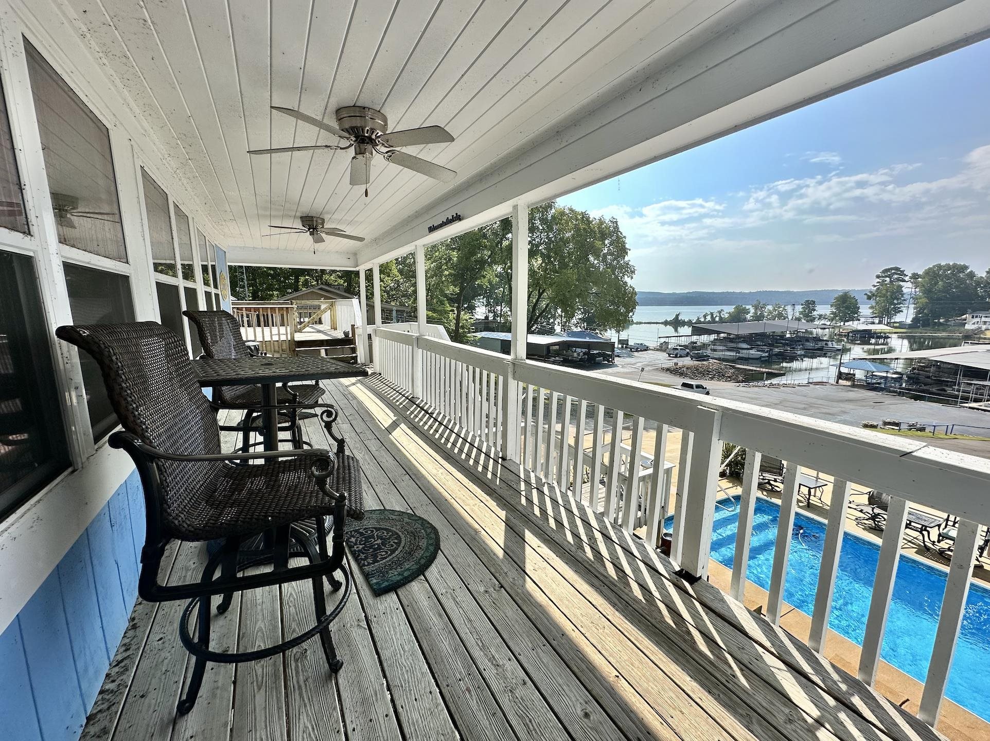 Wooden terrace featuring ceiling fan and a water view