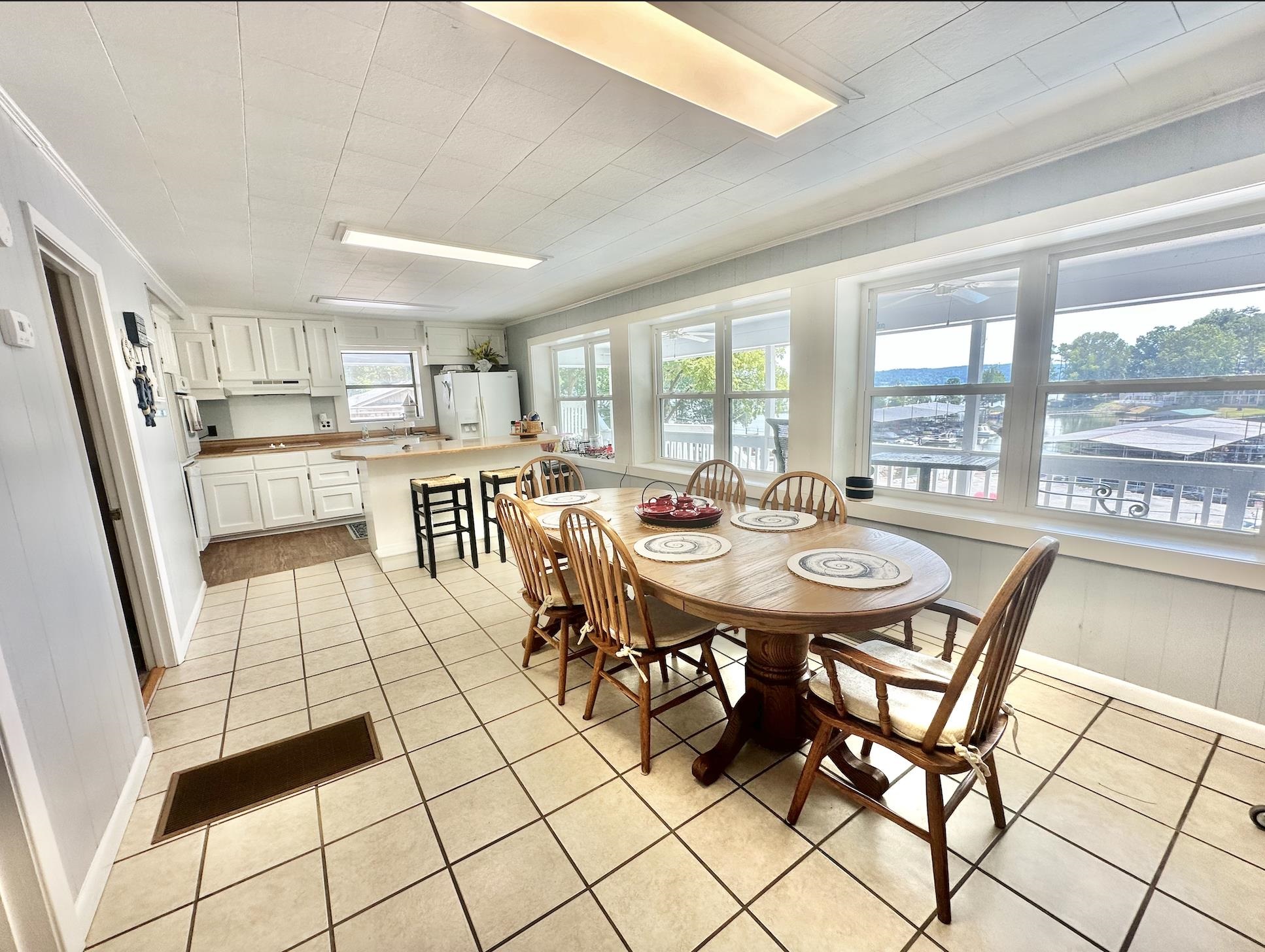 Dining area featuring ornamental molding, a healthy amount of sunlight, and light tile patterned floors