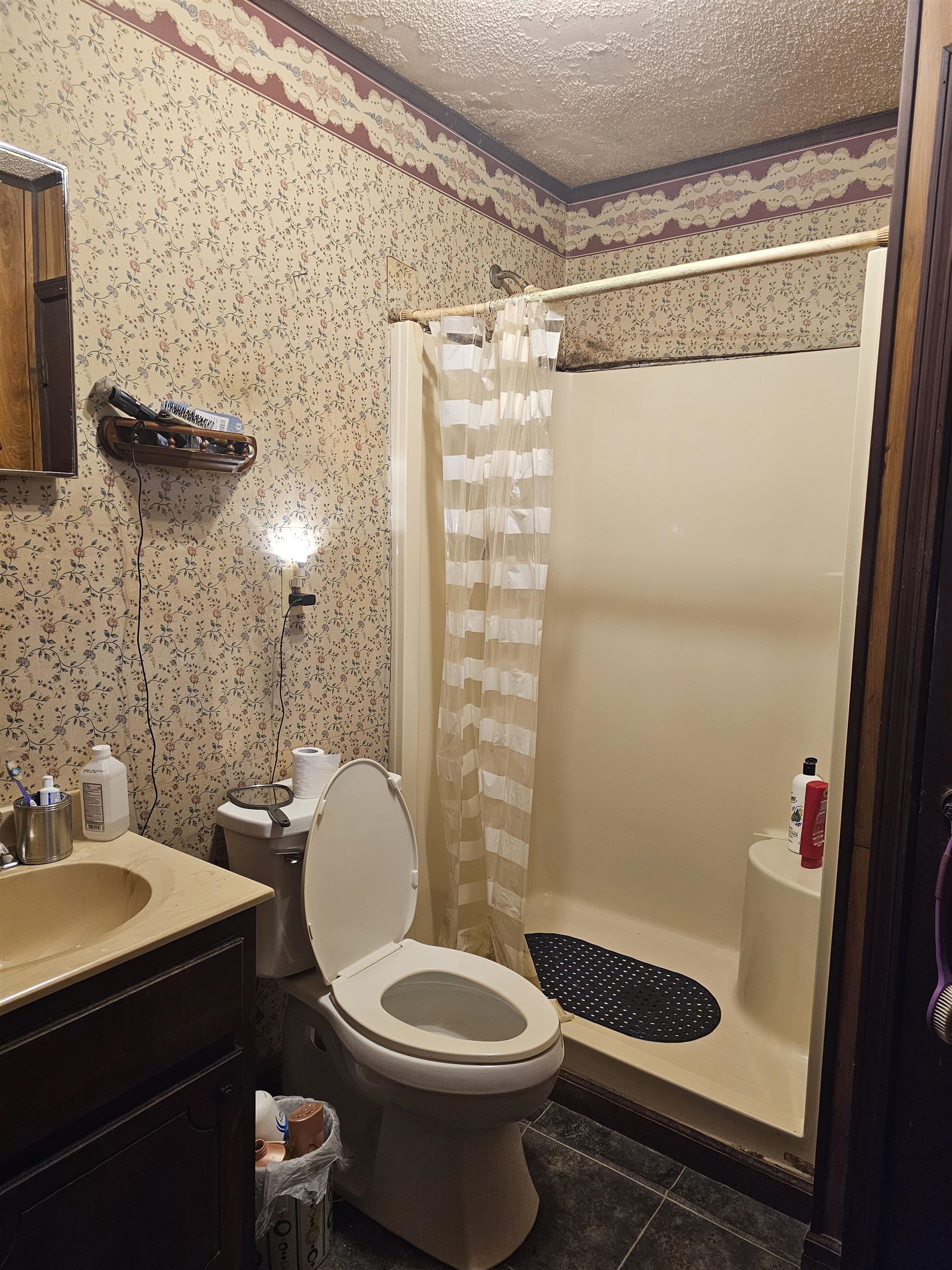 Bathroom featuring a shower with shower curtain, vanity, tile patterned floors, a textured ceiling, and toilet