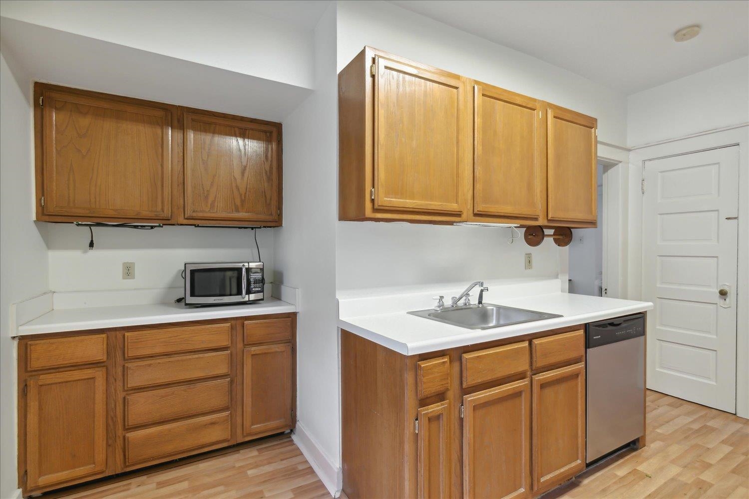 Kitchen with appliances with stainless steel finishes, sink, and light wood-type flooring