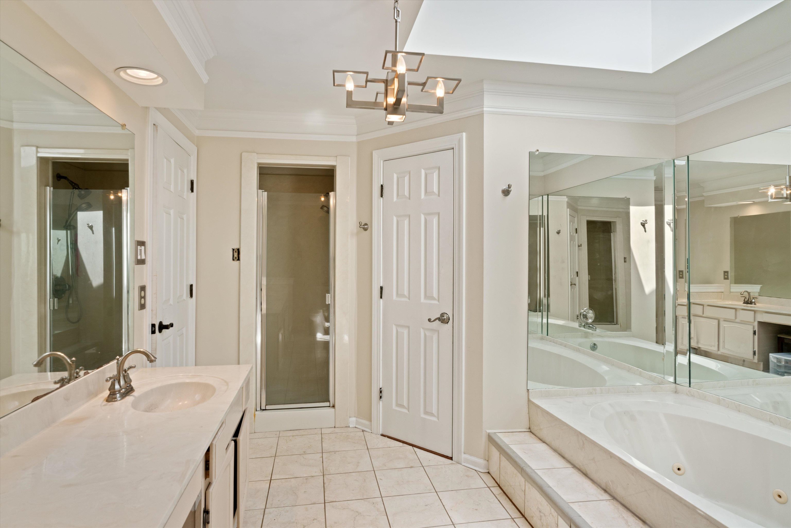 Bathroom with independent shower and bath, ornamental molding, vanity, and tile patterned floors