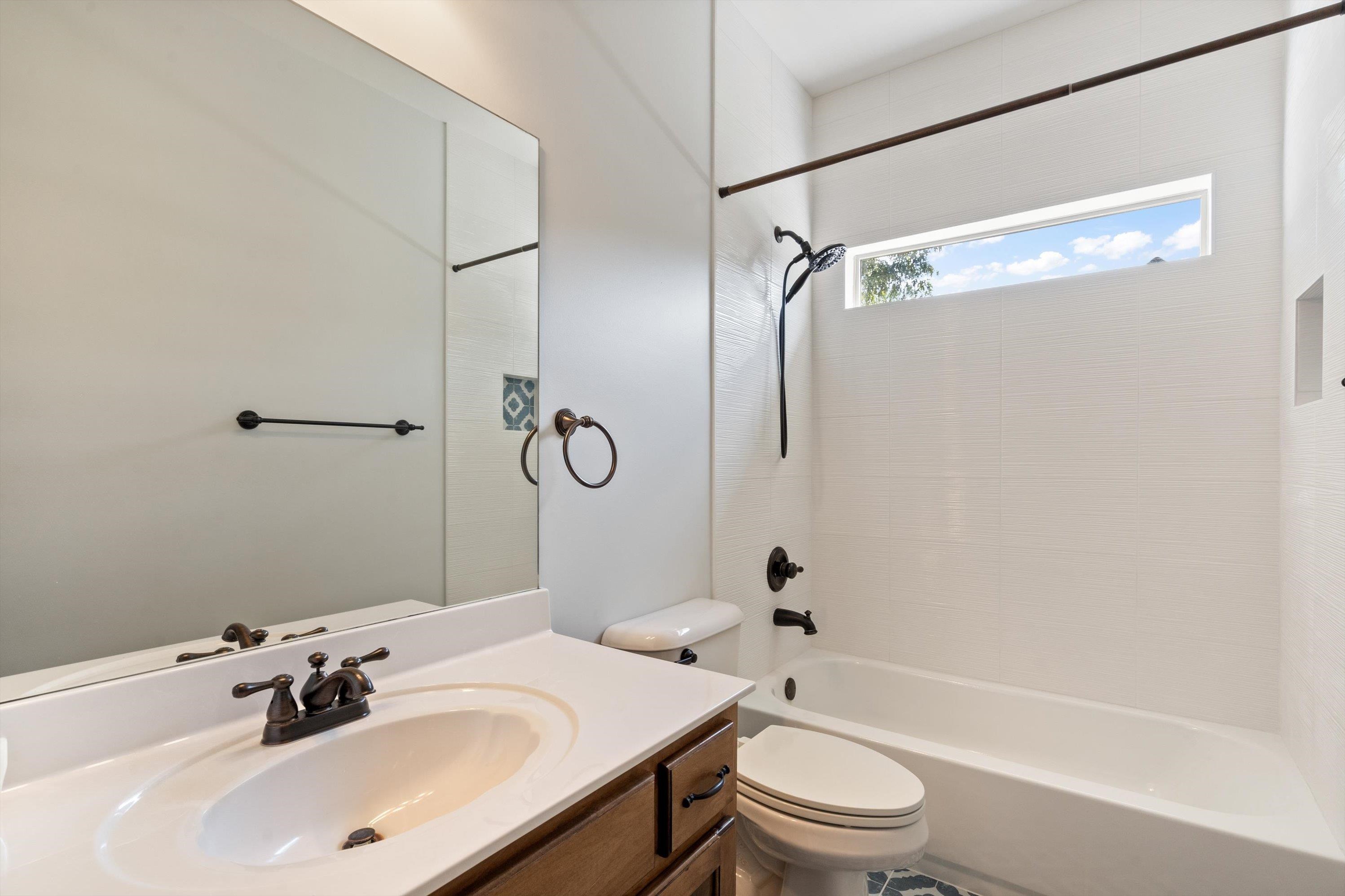 Full bathroom with toilet,  shower combination, and vanity