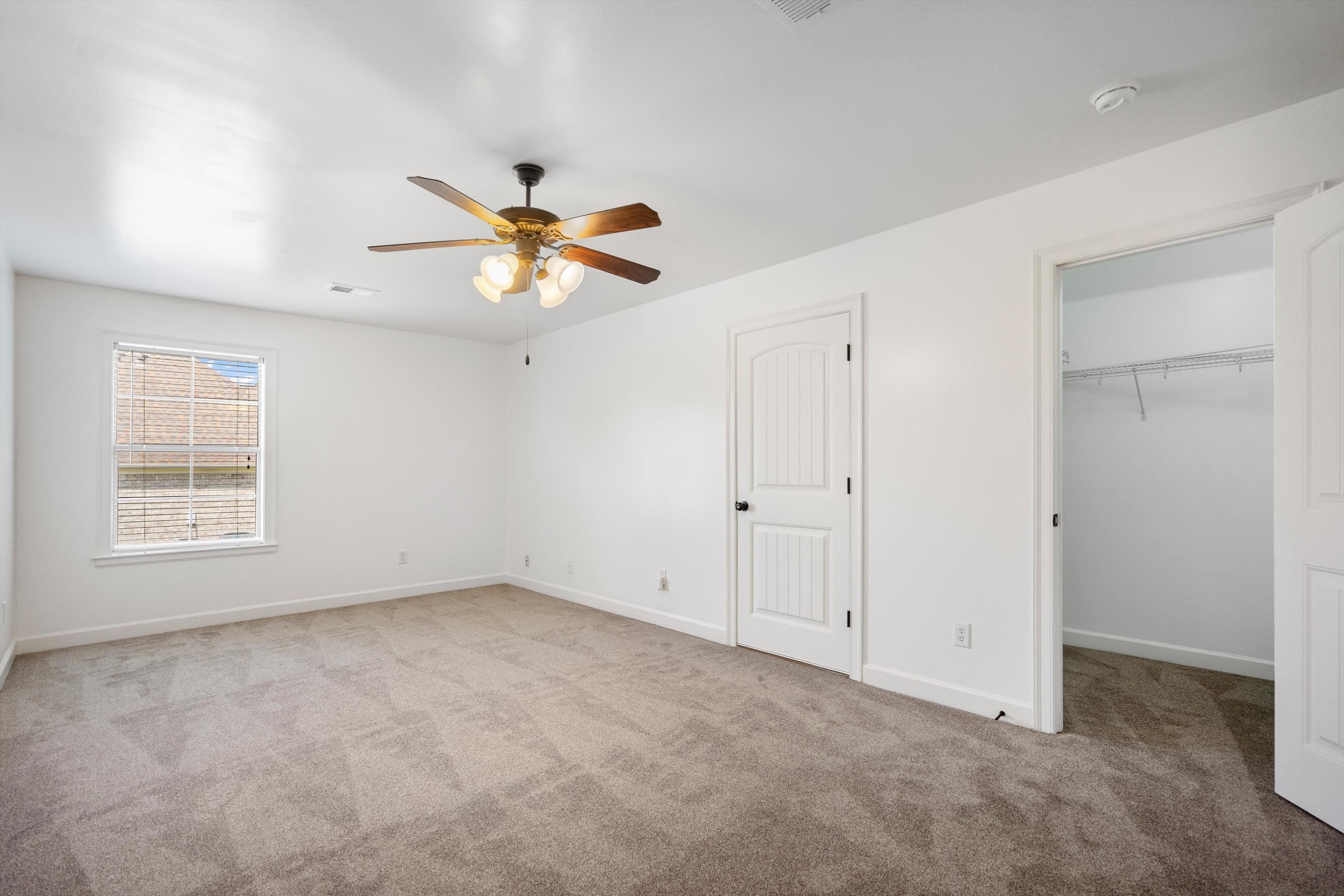 Unfurnished bedroom featuring ceiling fan and light carpet