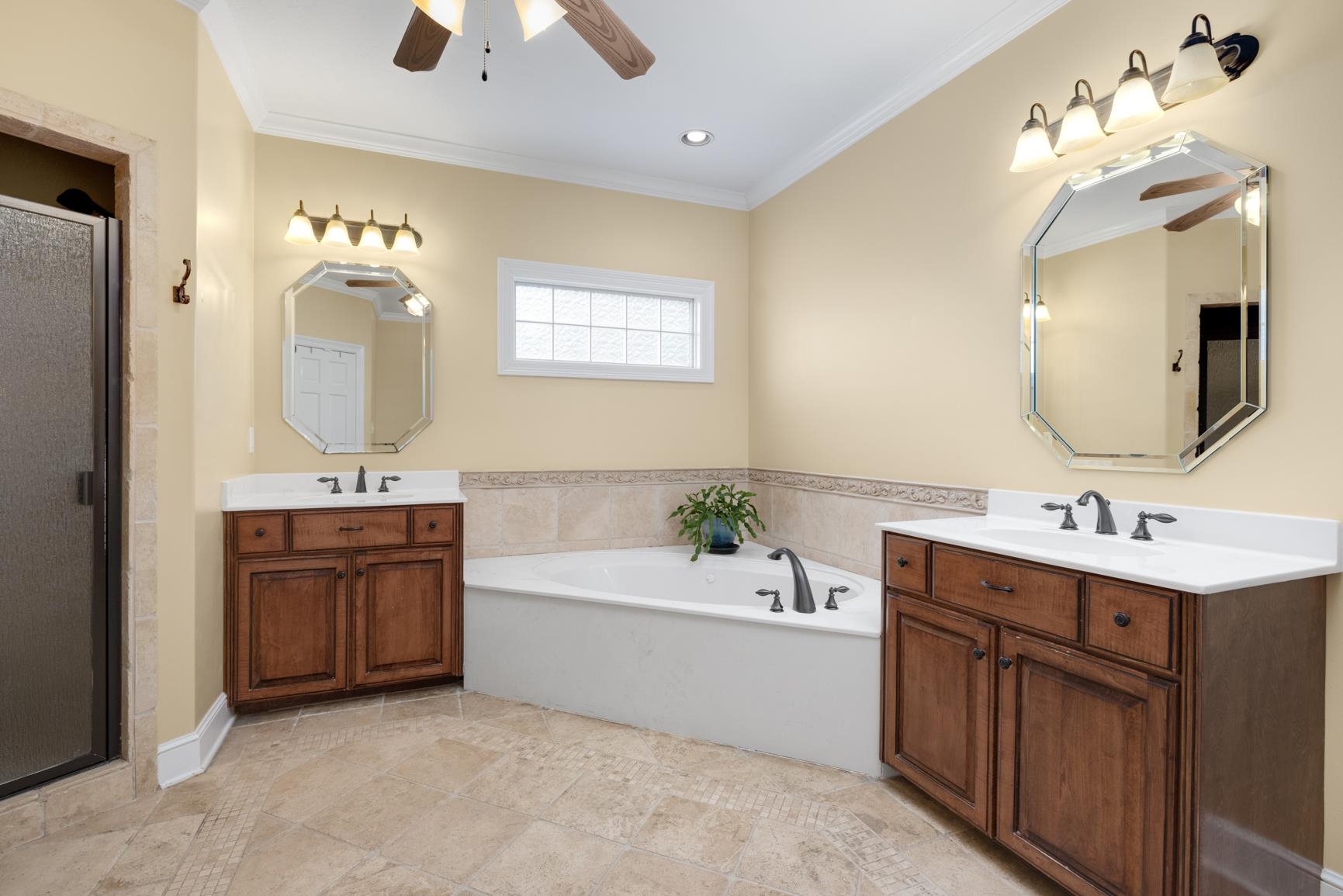 Bathroom featuring tile patterned flooring, ceiling fan, ornamental molding, and double sink vanity