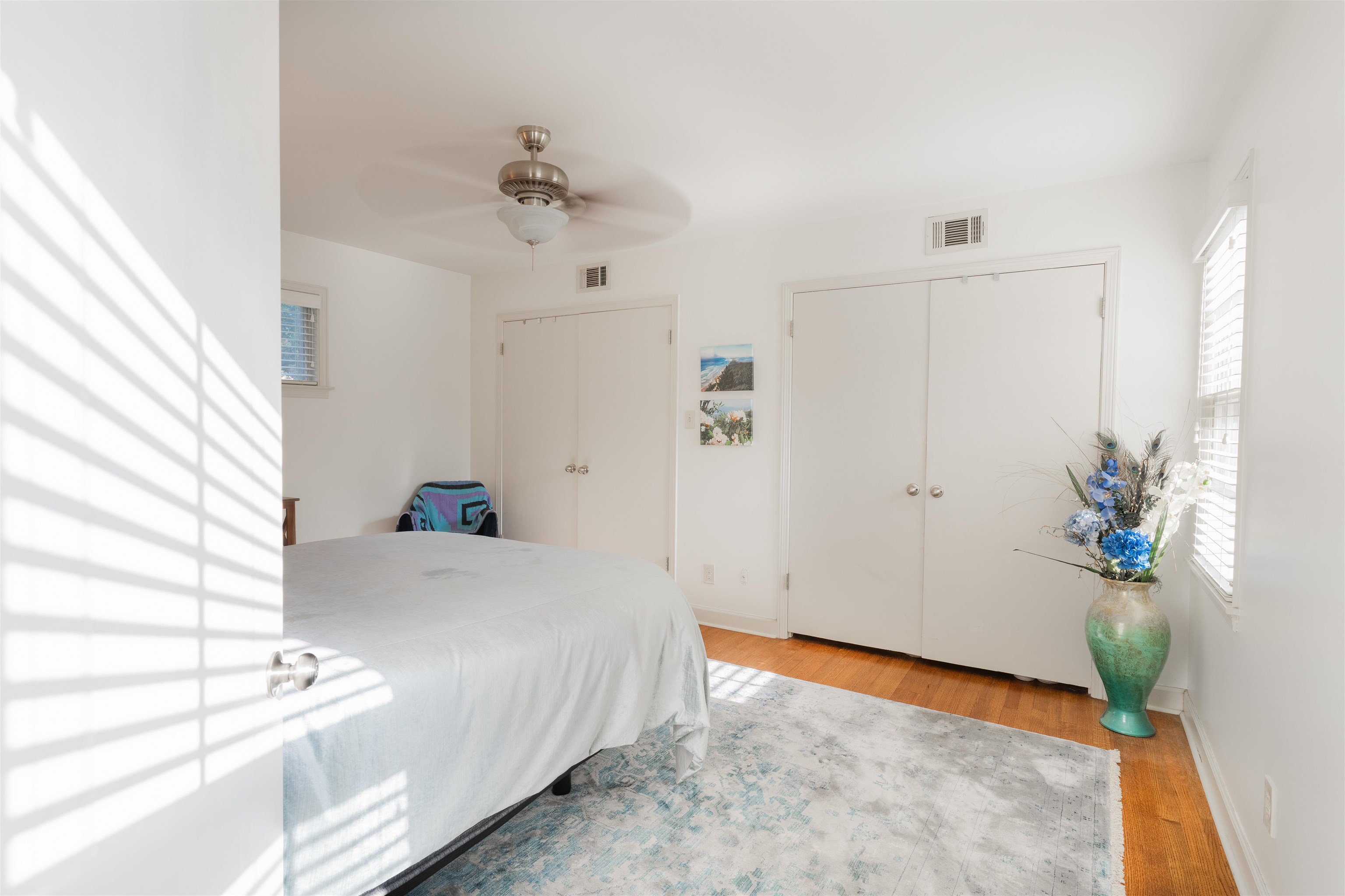 Bedroom with ceiling fan, a closet, and light hardwood / wood-style floors