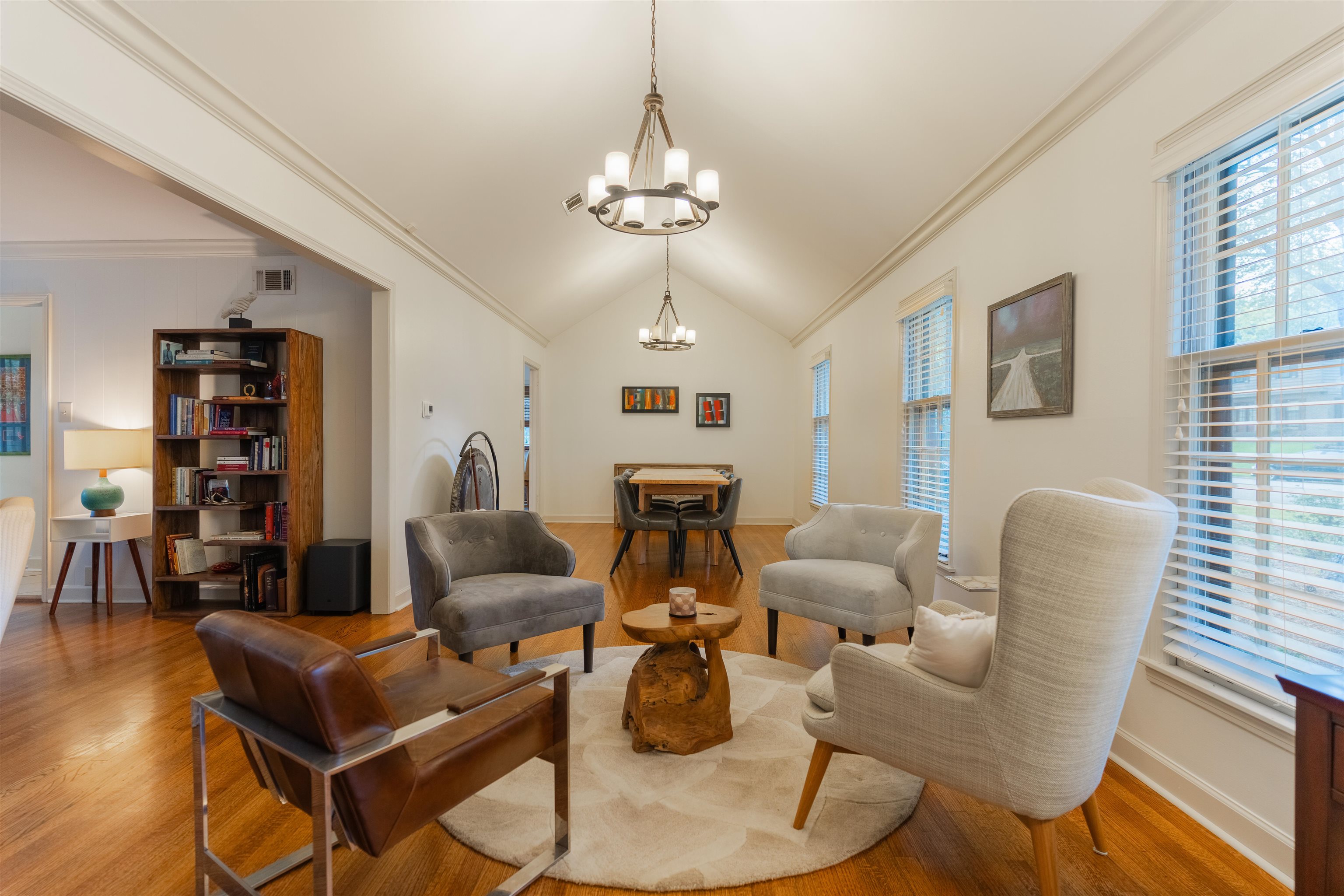 Living room with crown molding, wood-type flooring, and a chandelier