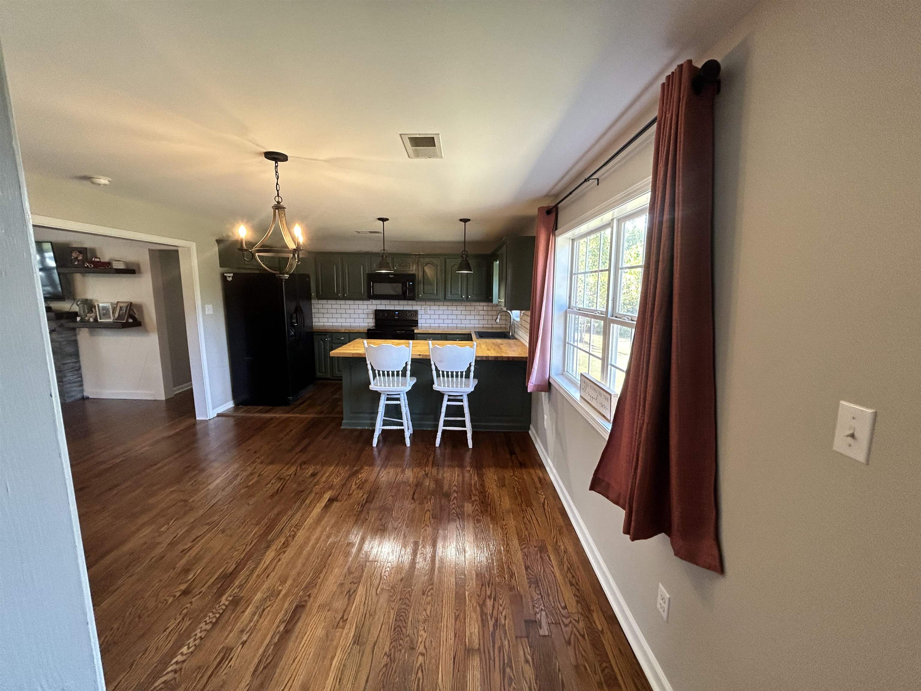 Unfurnished dining area featuring dark hardwood / wood-style floors and an inviting chandelier