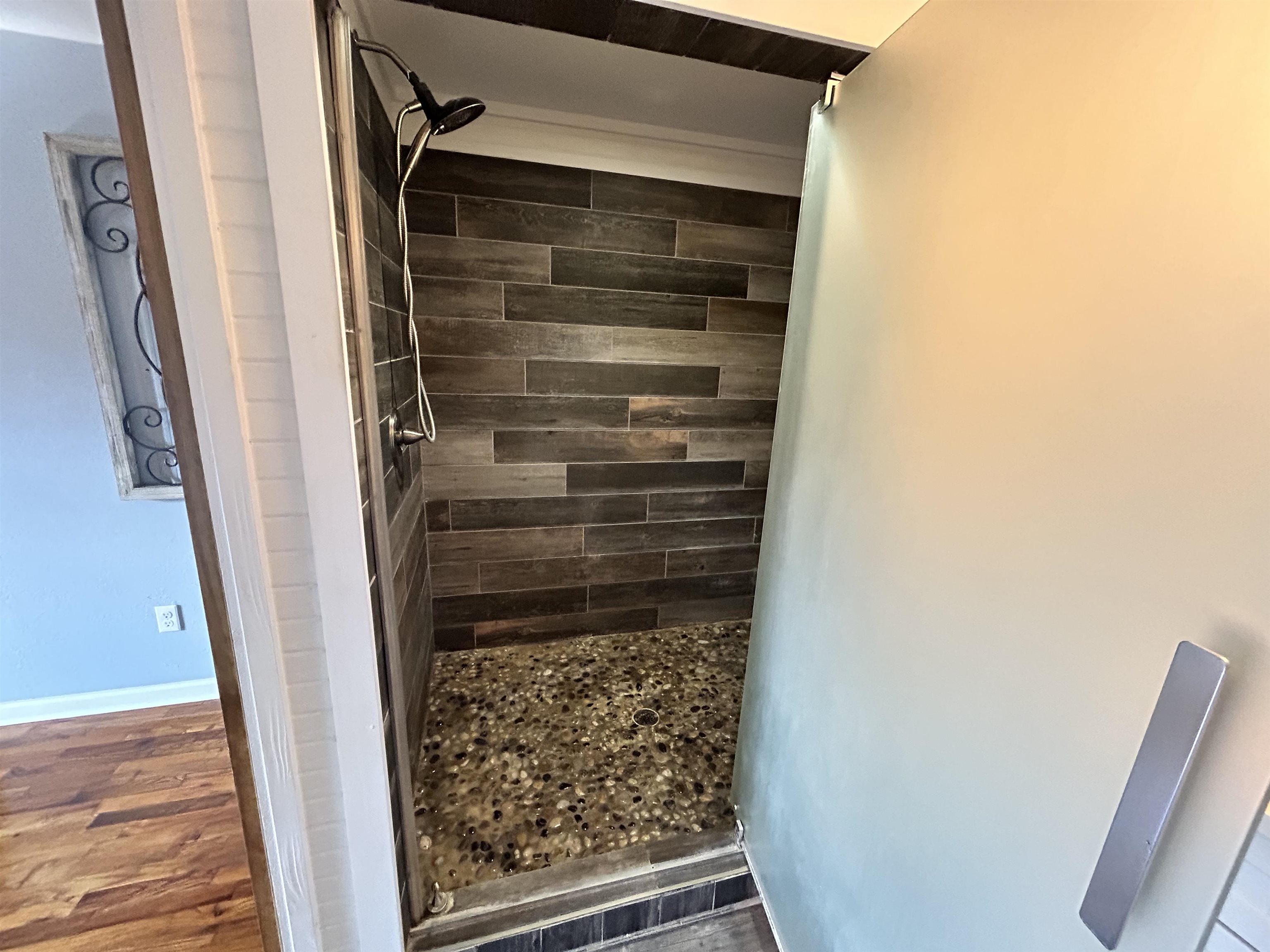 Bathroom featuring hardwood / wood-style flooring and a tile shower