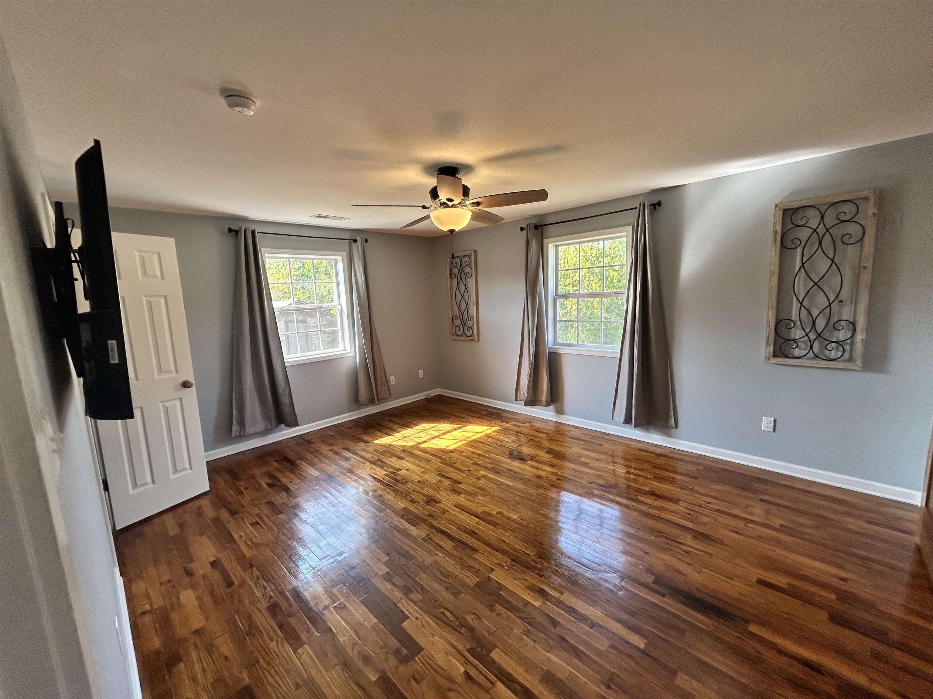 Unfurnished room with ceiling fan and dark hardwood / wood-style flooring