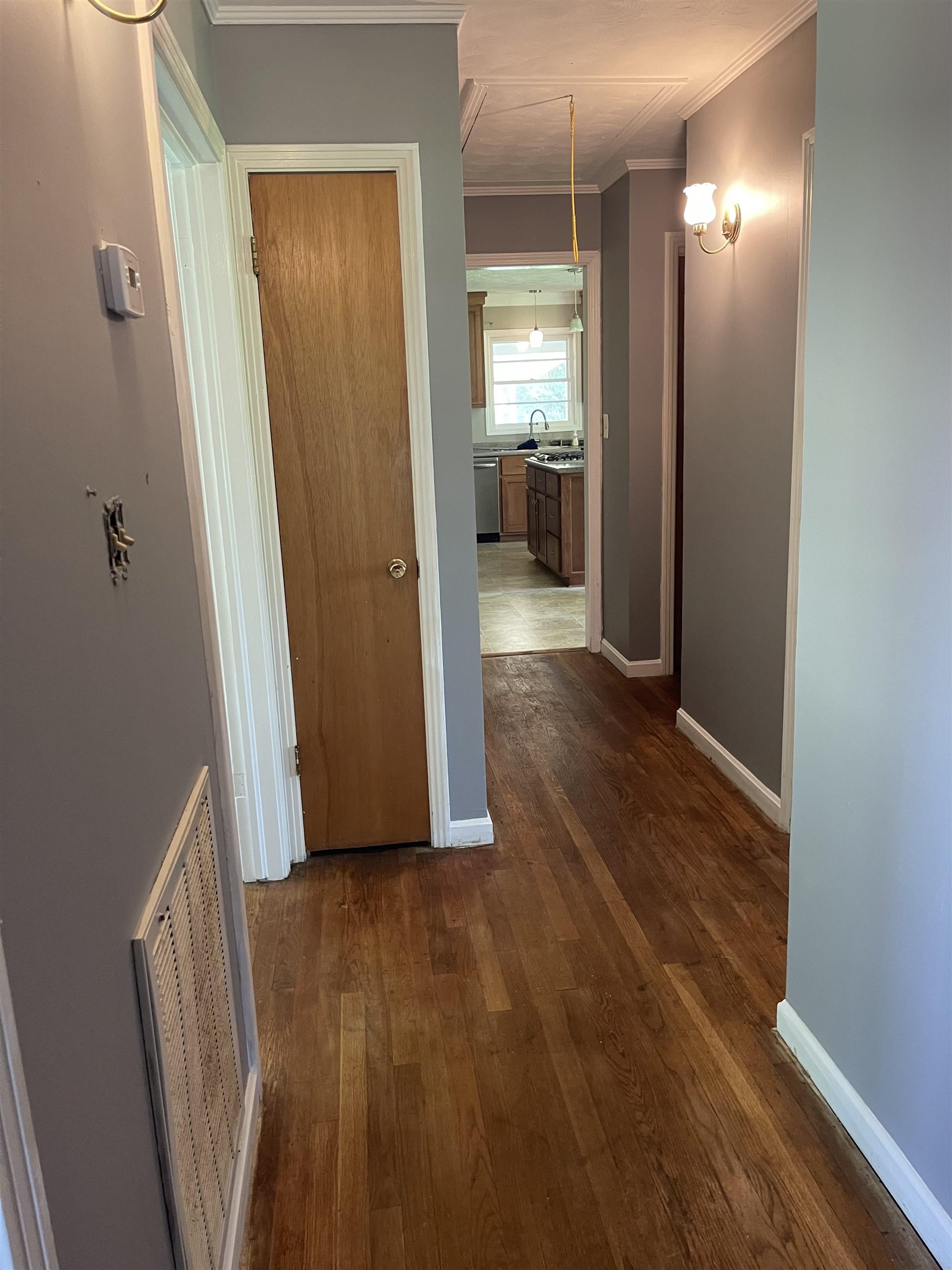 Corridor featuring sink, crown molding, and dark hardwood / wood-style flooring