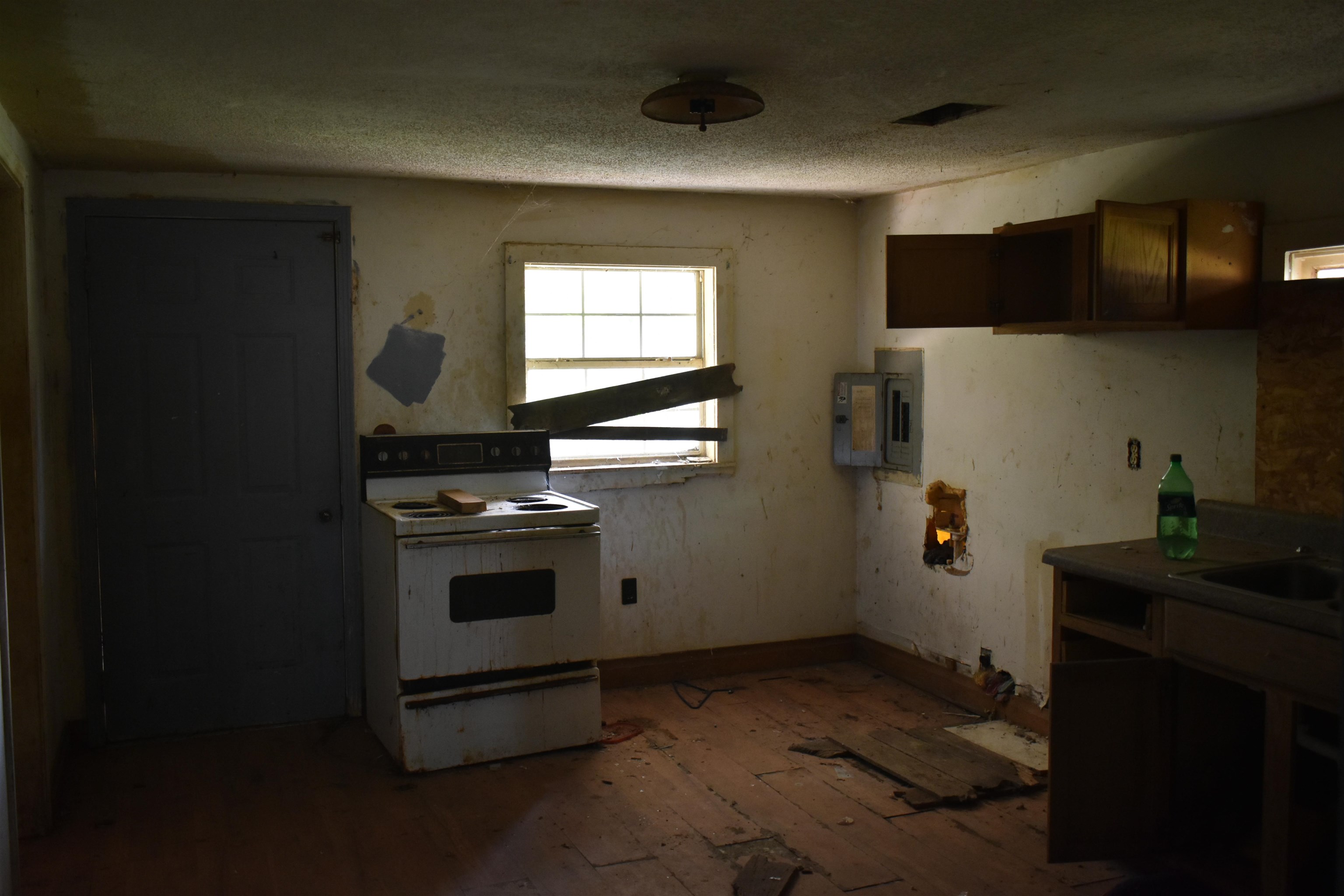 Kitchen featuring white range with electric cooktop, a textured ceiling, hardwood / wood-style floors, and electric panel