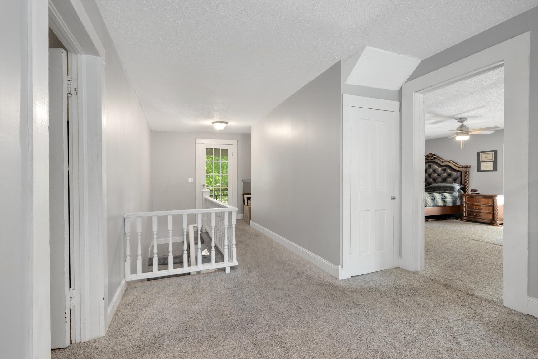 Hallway featuring light carpet