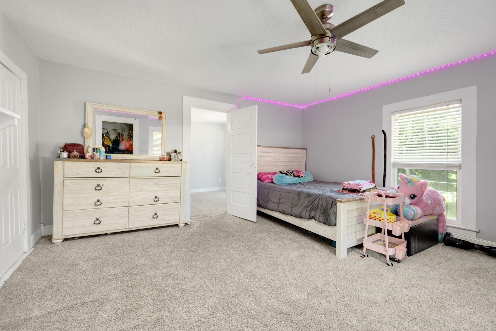 Carpeted bedroom featuring ceiling fan