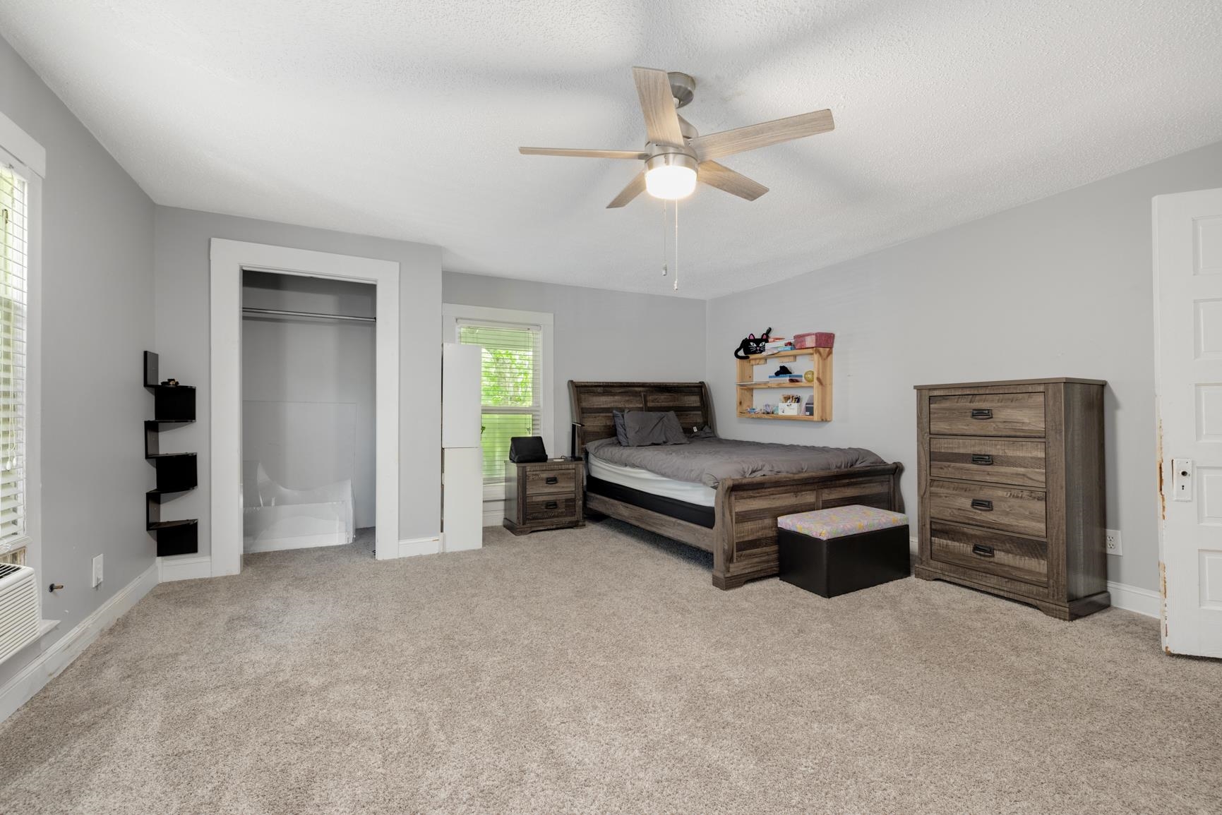 Bedroom with ceiling fan and light carpet