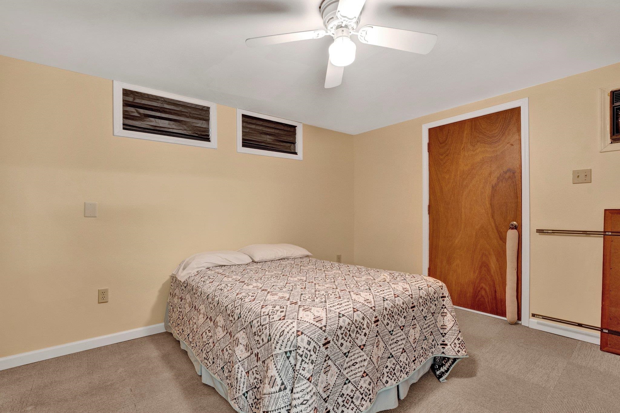 Carpeted bedroom with ceiling fan