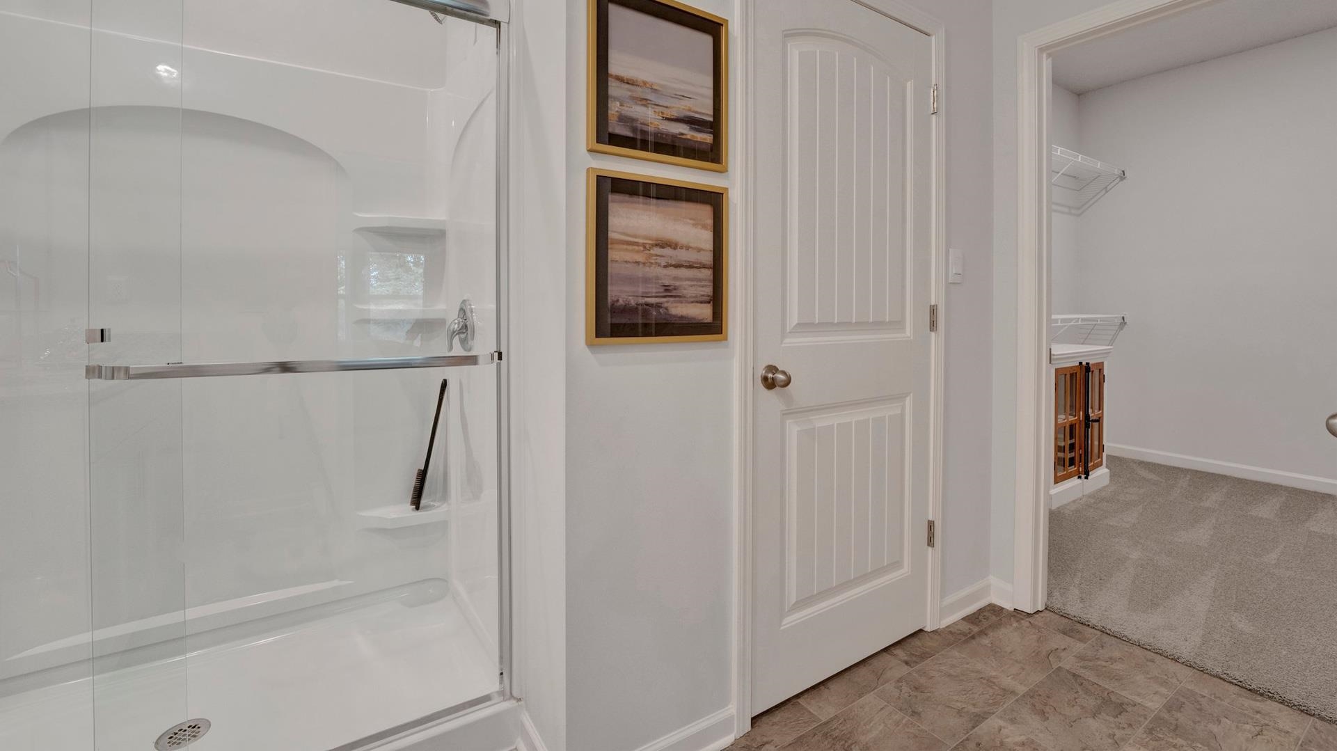 Bathroom with a shower with shower door, vanity, and tile floors