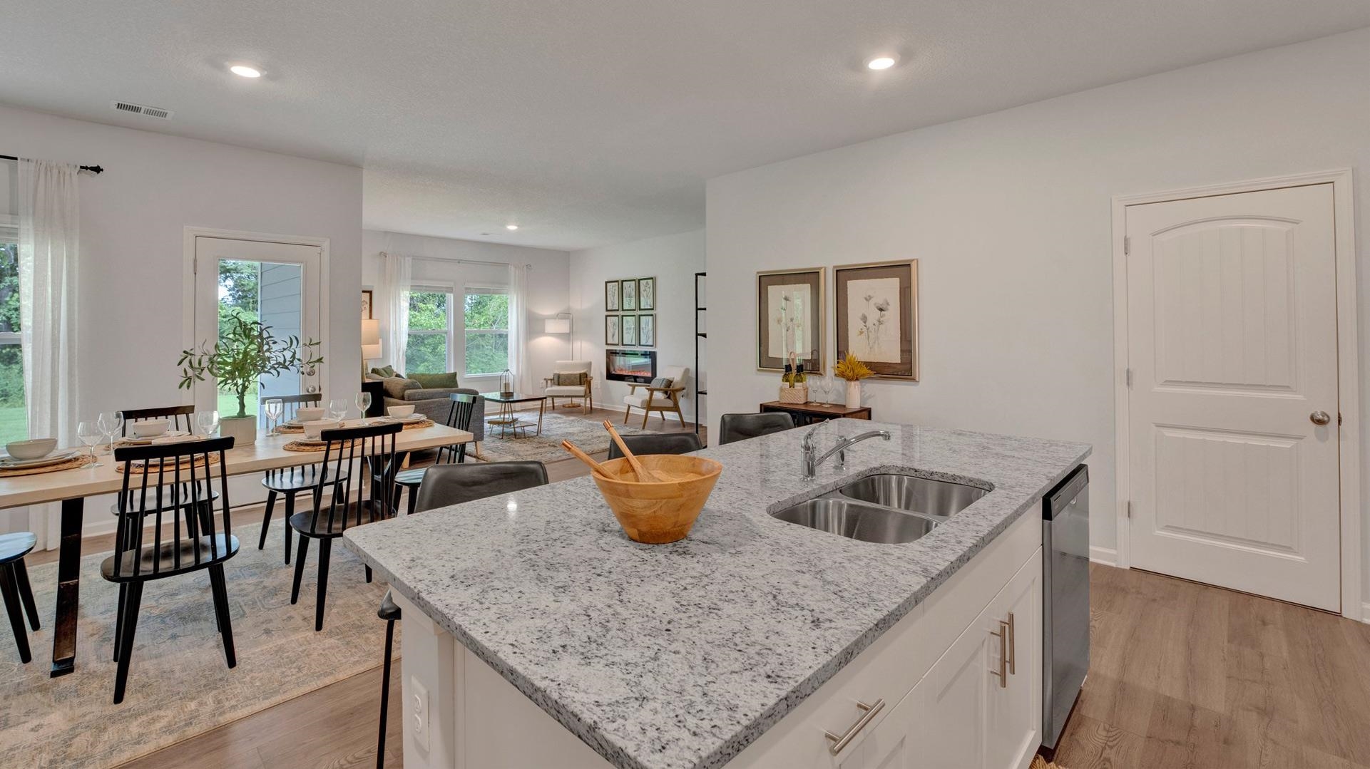 Kitchen featuring sink, white cabinets, a center island with sink, and hardwood / wood-style floors
