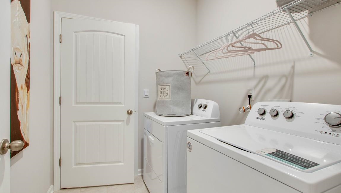 Laundry room with light tile patterned floors and independent washer and dryer