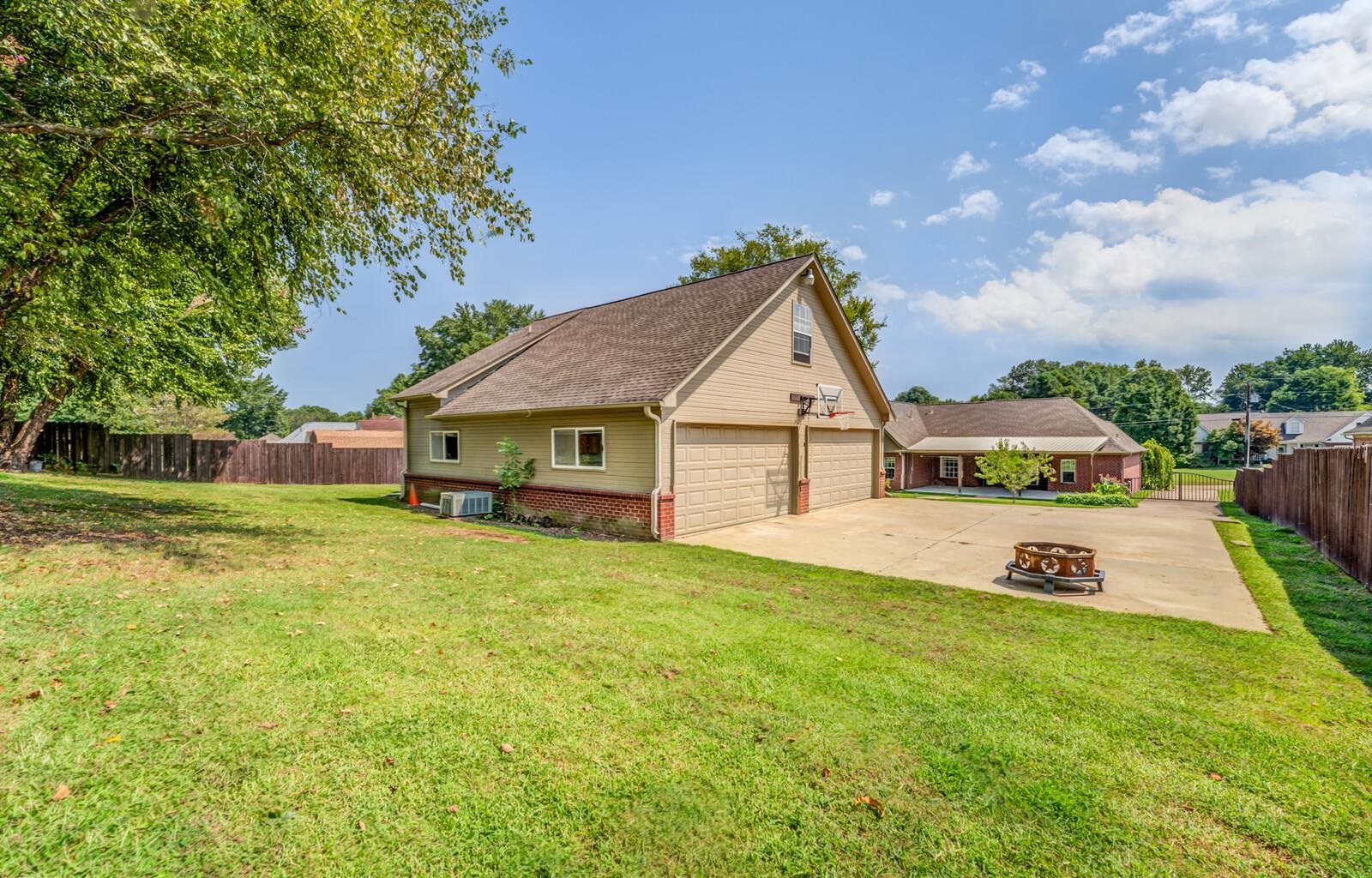 View of property exterior featuring central AC, a patio, a fire pit, and a lawn