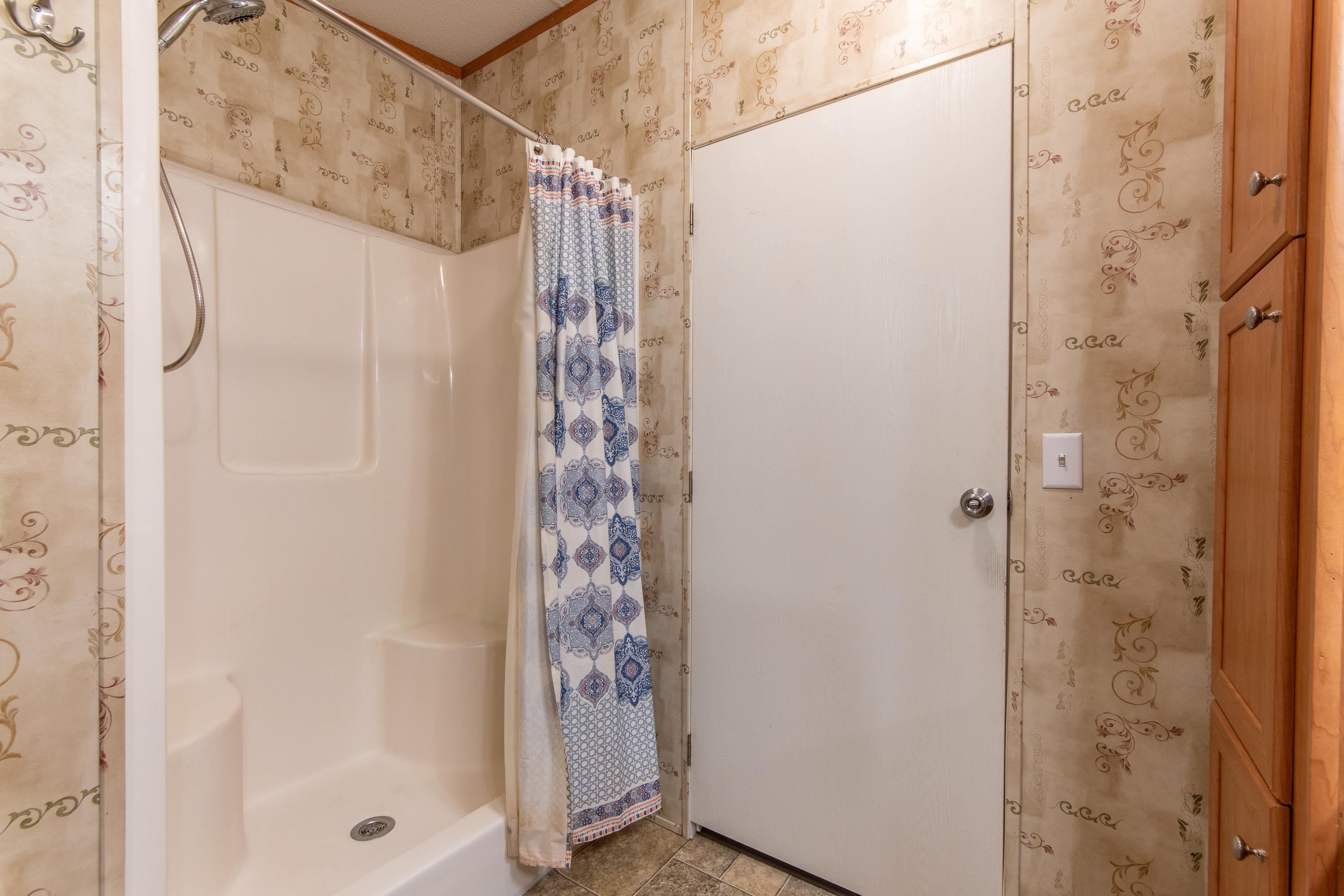 Bathroom featuring walk in shower and tile patterned floors