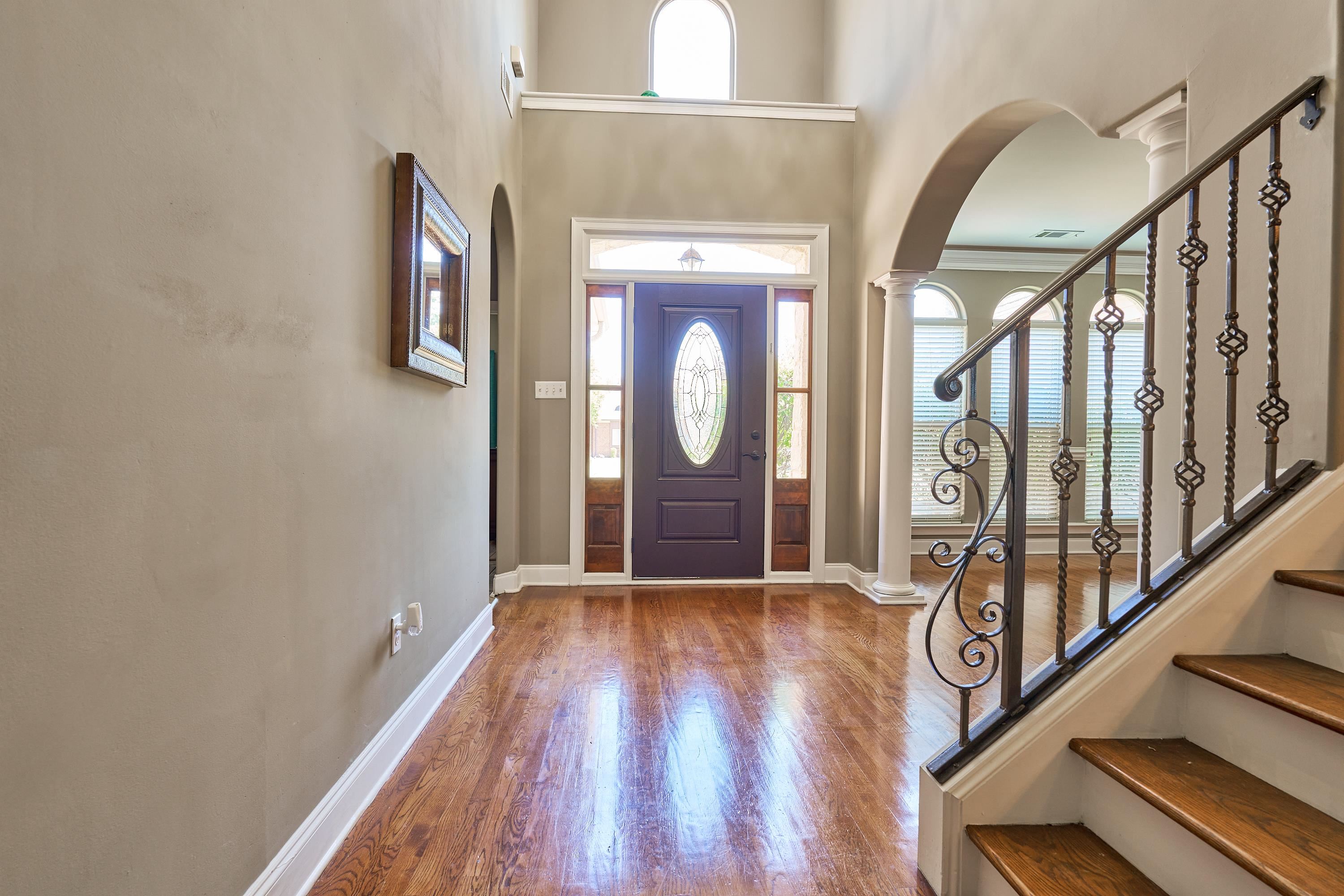 Majestic 2 story Foyer entrance featuring decorative columns, hardwood floors,