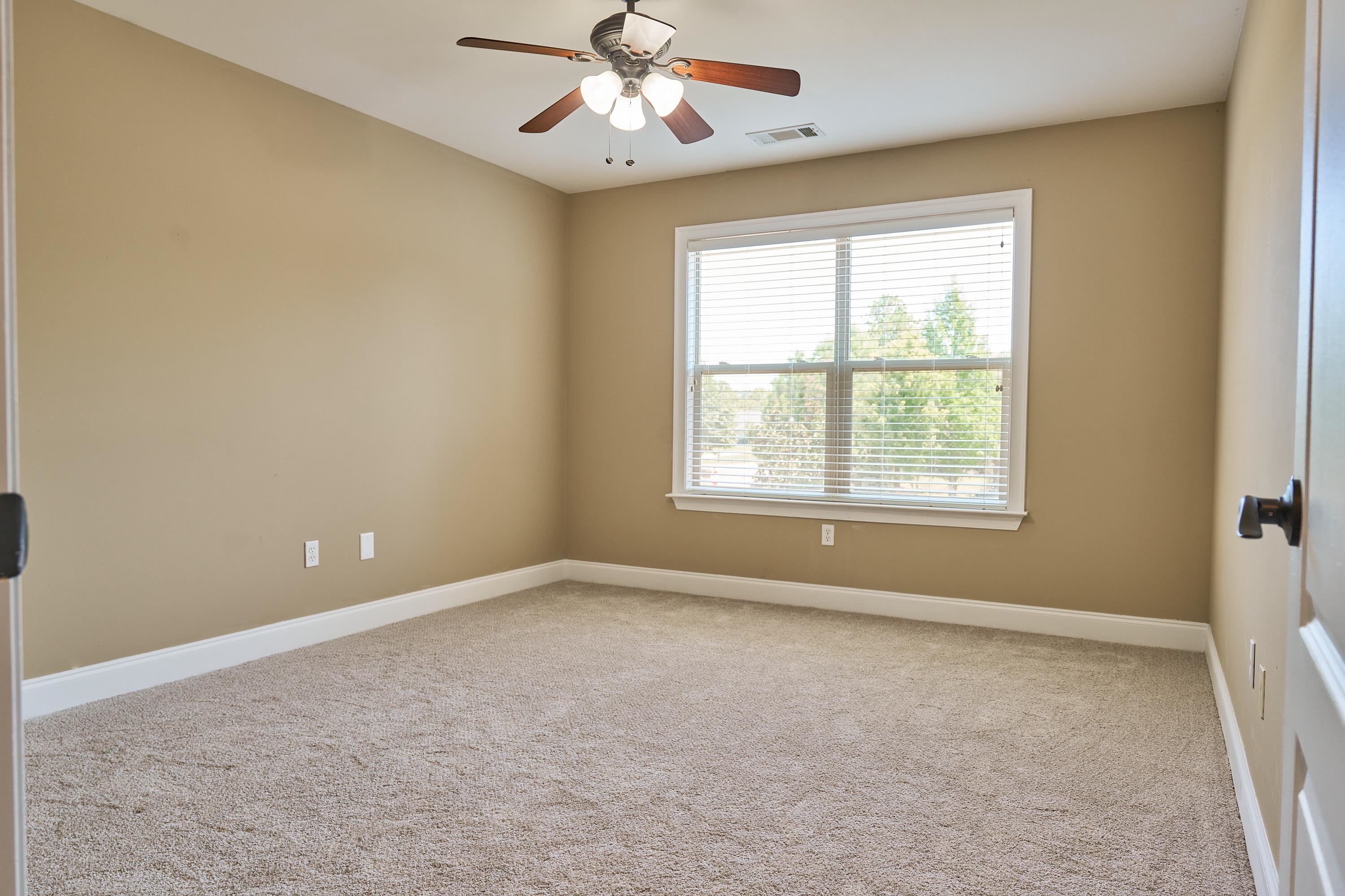 Carpeted spare room featuring a wealth of natural light.  Could be an office or bedroom.