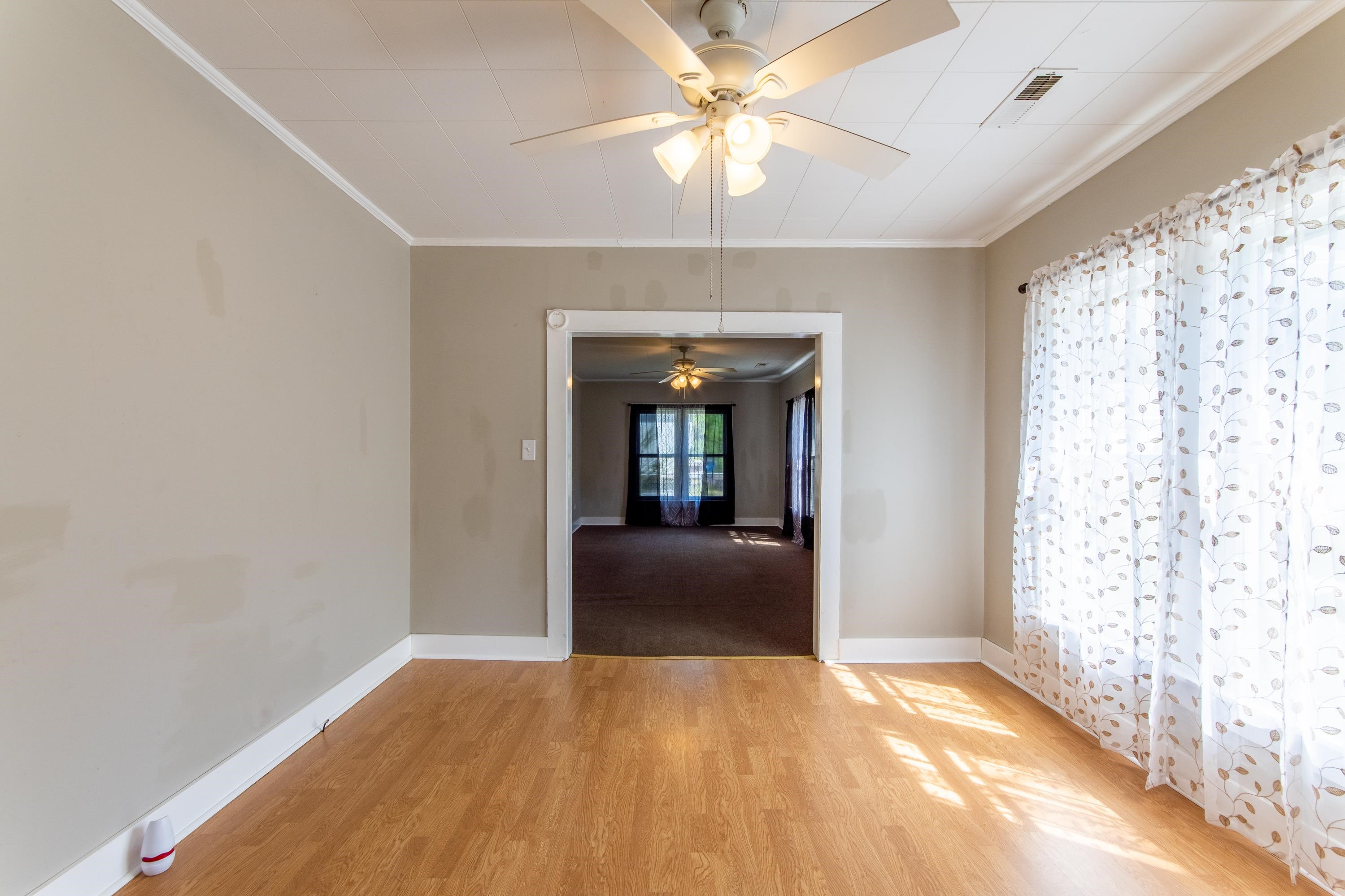 Spare room featuring ceiling fan, ornamental molding, and light hardwood / wood-style flooring