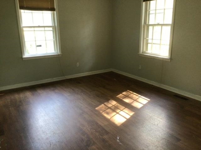 Spare room featuring dark wood-type flooring