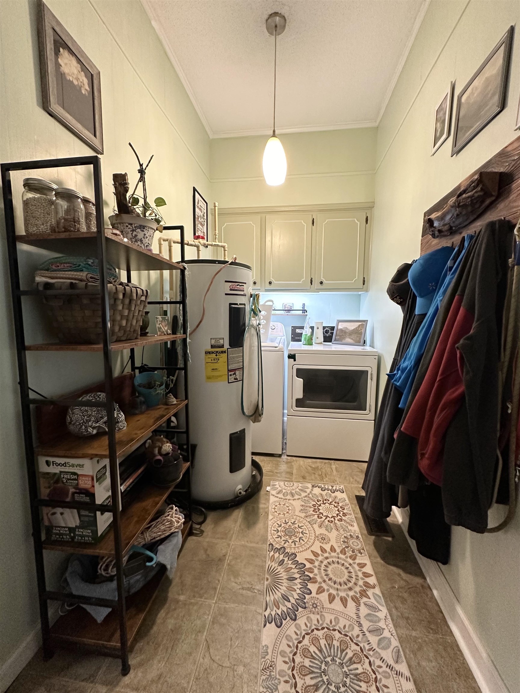 Clothes washing area featuring light tile patterned flooring, cabinets, independent washer and dryer, and electric water heater