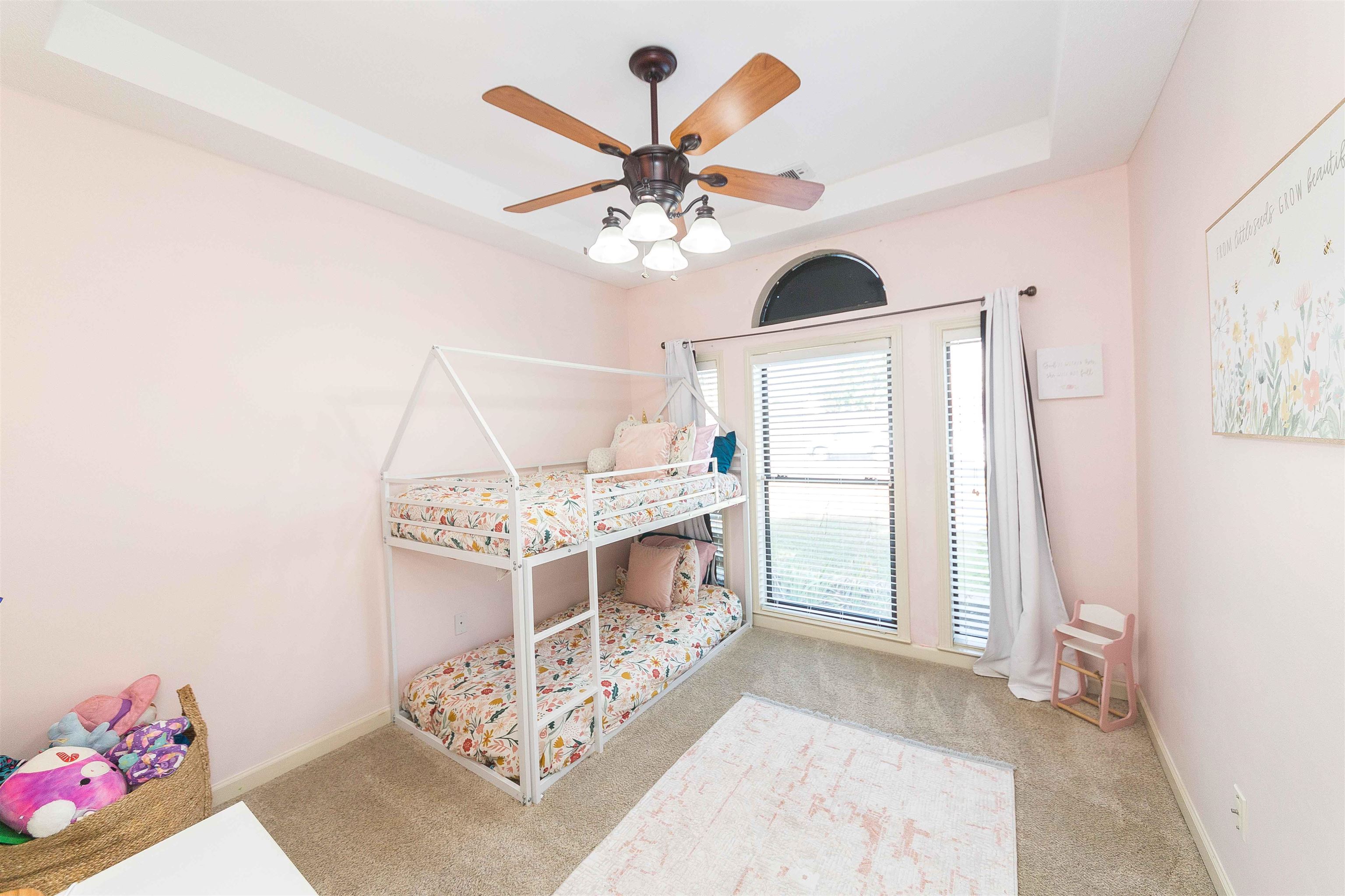 2nd bedroom featuring a raised ceiling and ceiling fan