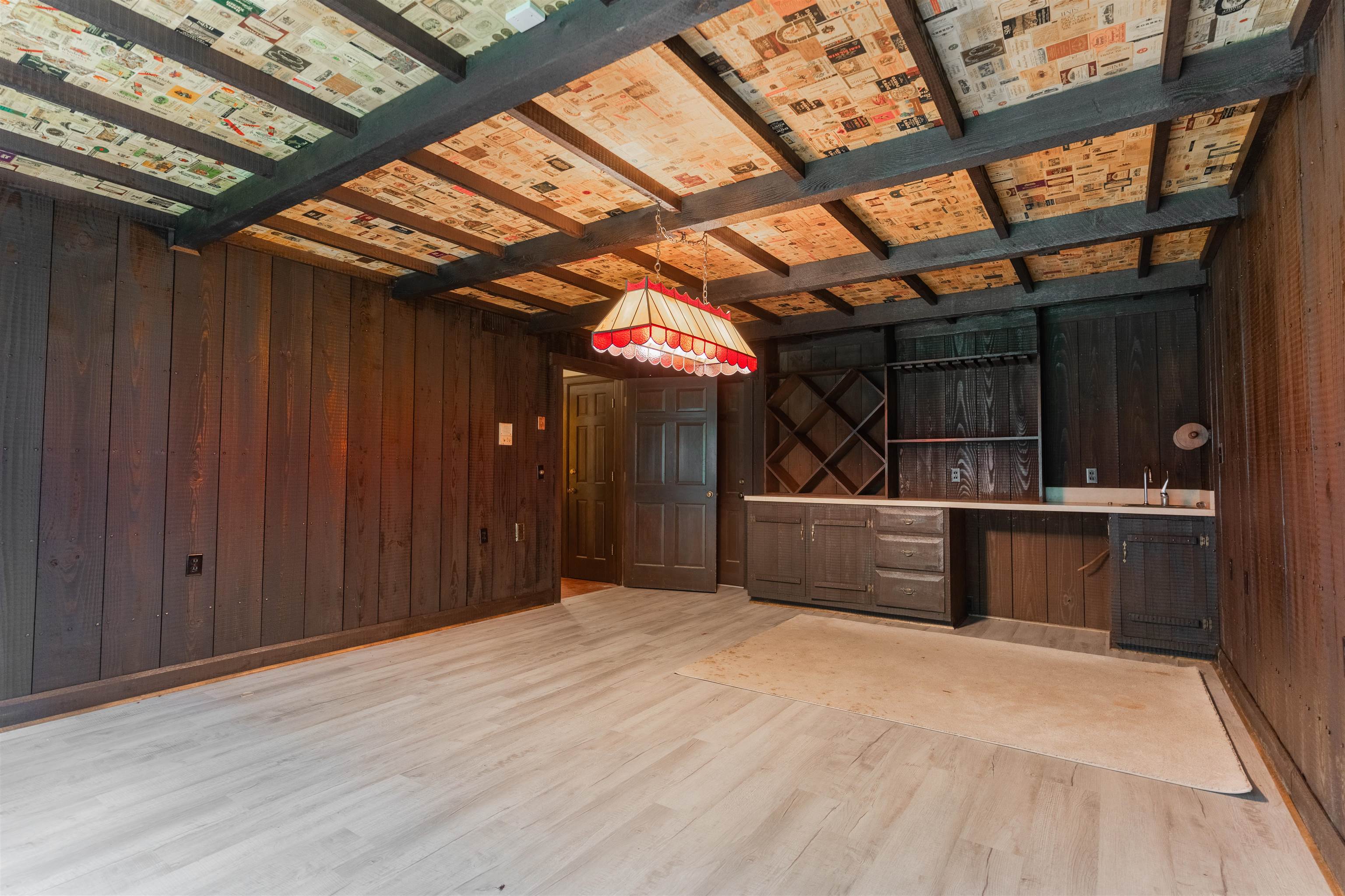 Interior space featuring wood walls, light hardwood / wood-style floors, and wet bar. Wine cellar!