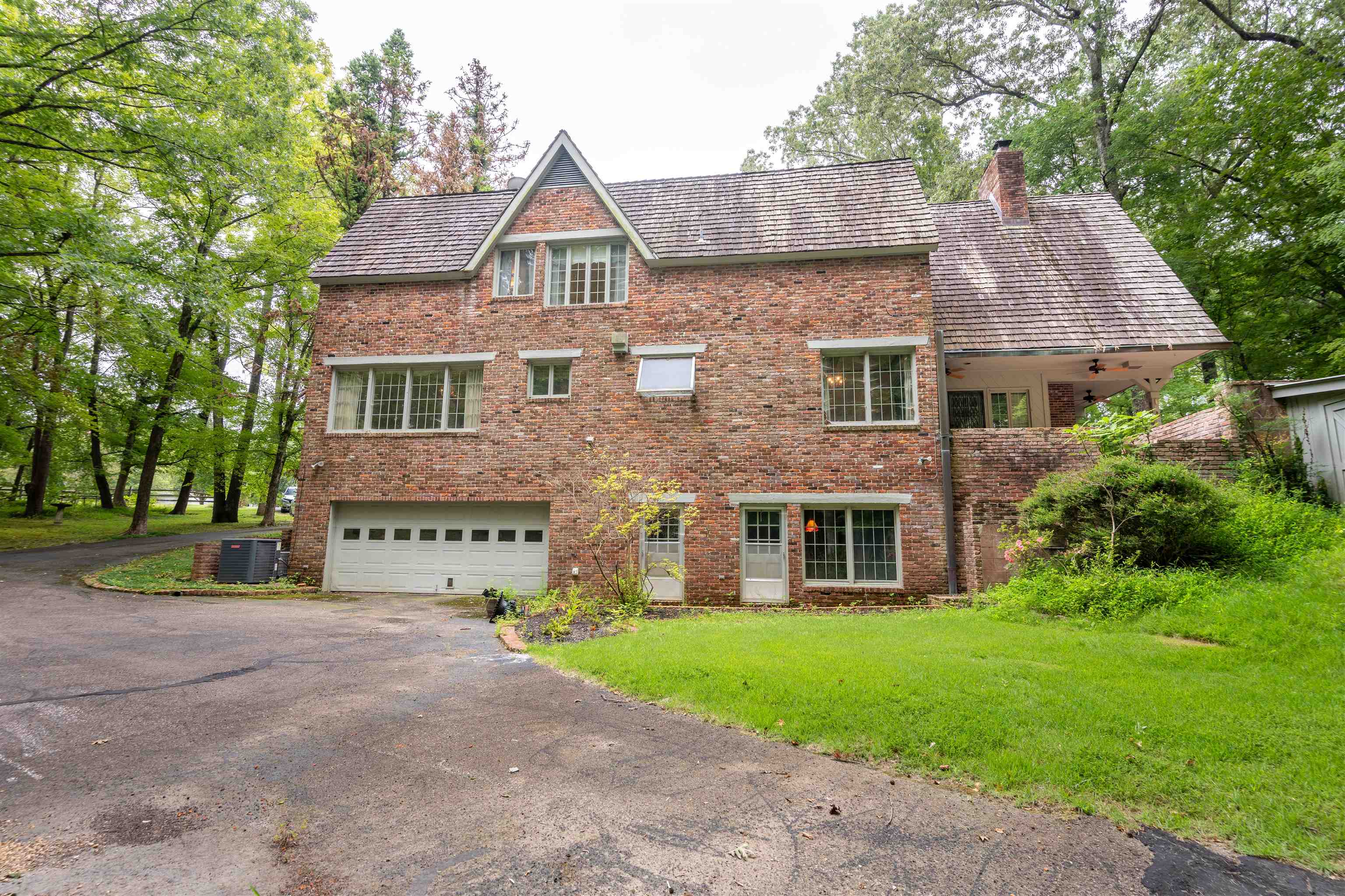 Rear of home with a garage, a front yard, and central air condition unit