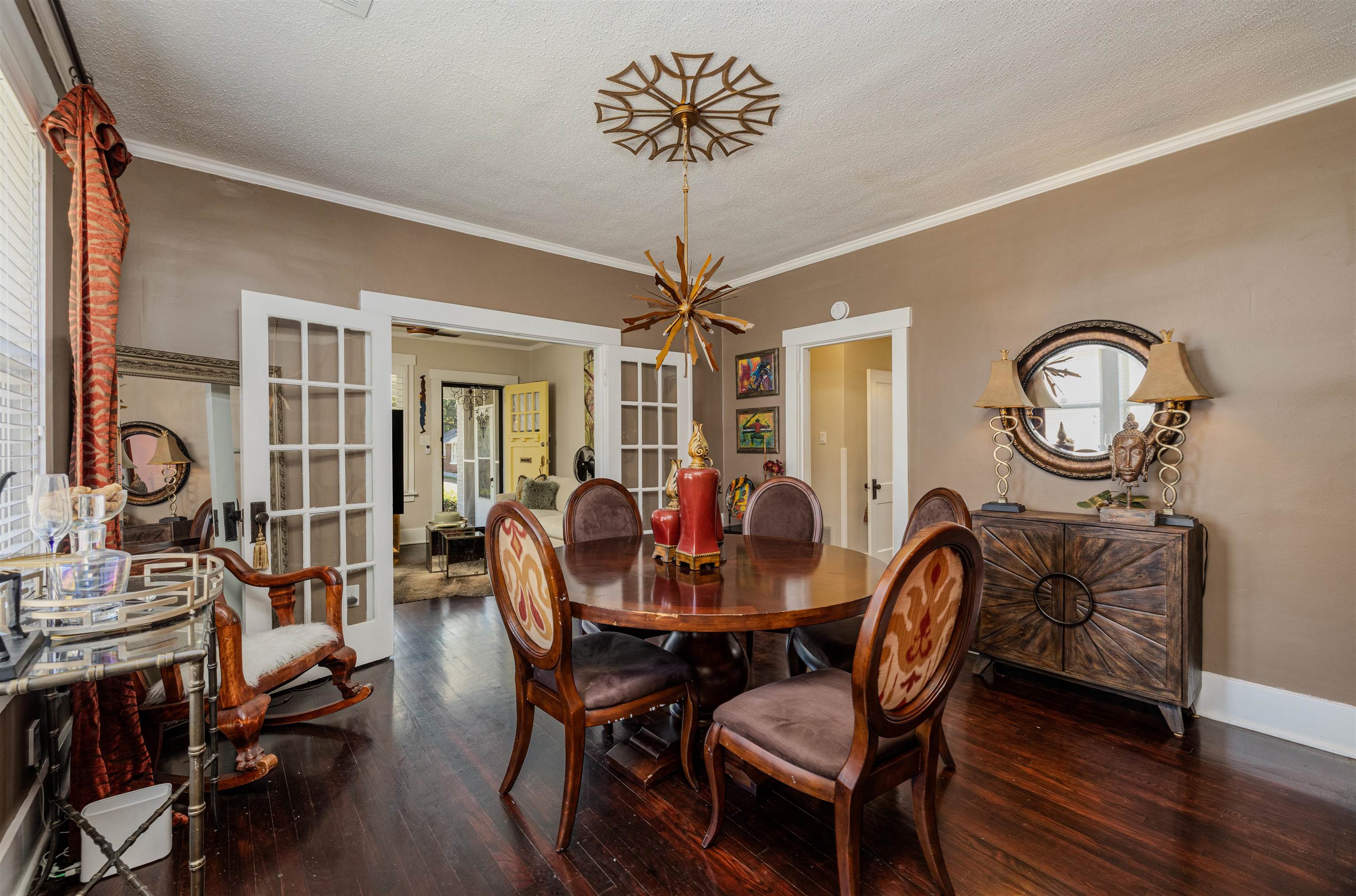 Dining room with a textured ceiling, dark hardwood / wood-style flooring, crown molding, and french doors