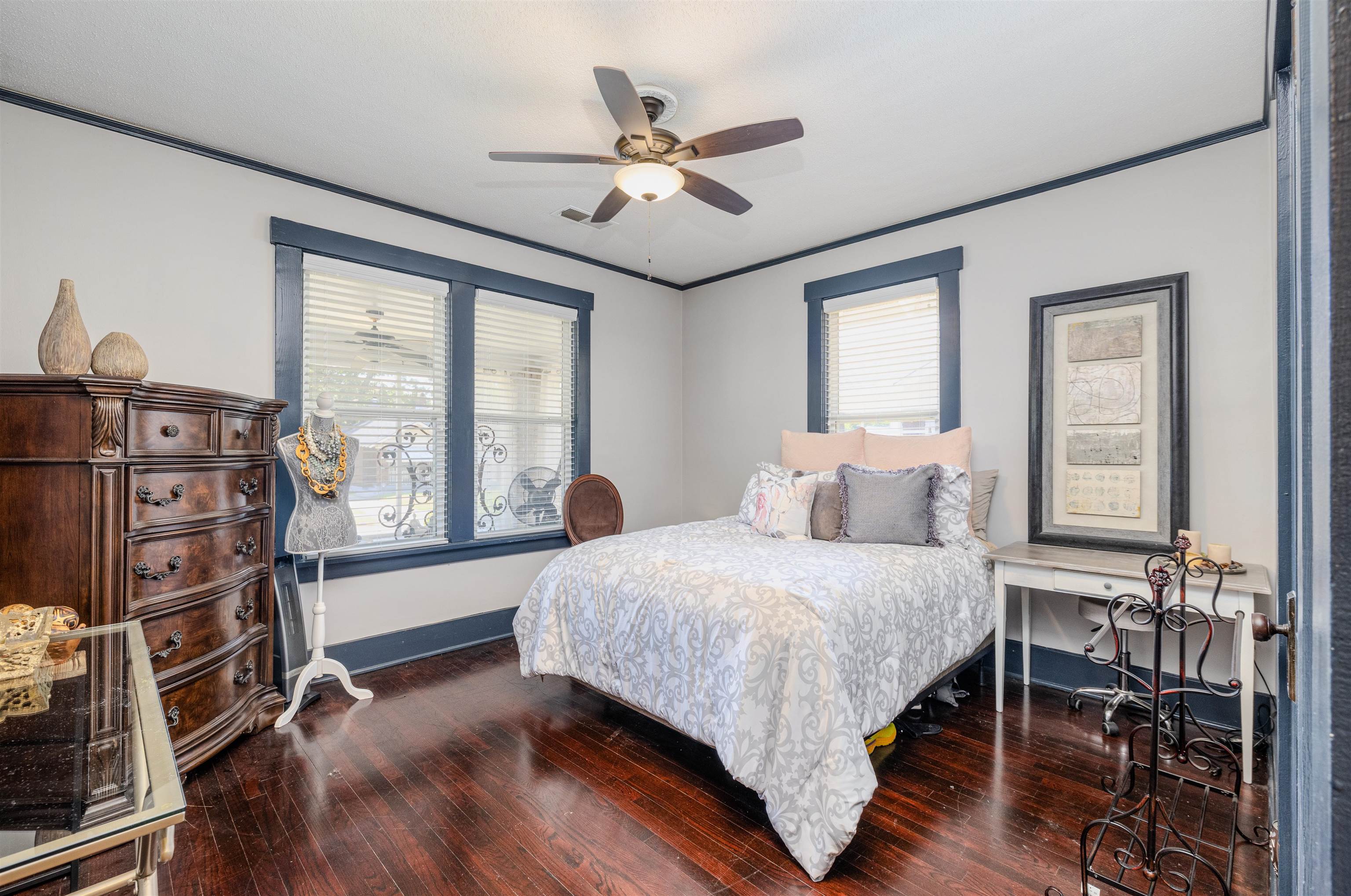 Bedroom featuring dark wood-type flooring, ceiling fan, and ornamental molding