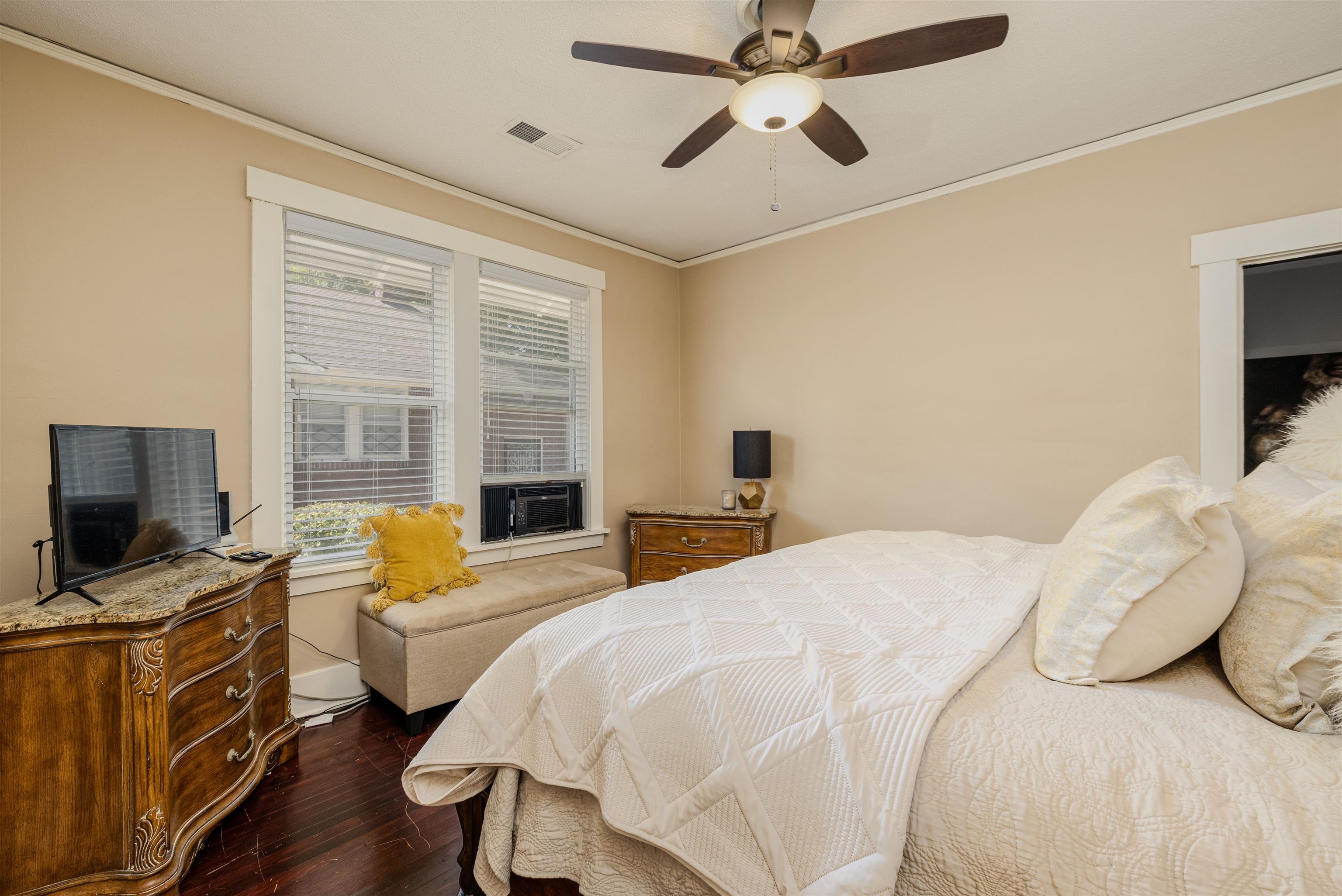 Bedroom with ornamental molding, ceiling fan, dark hardwood / wood-style floors, and cooling unit