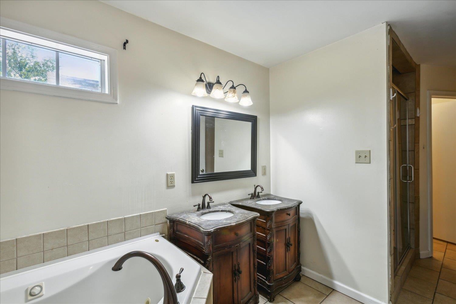 Bathroom with vanity, separate shower and tub, and tile patterned floors