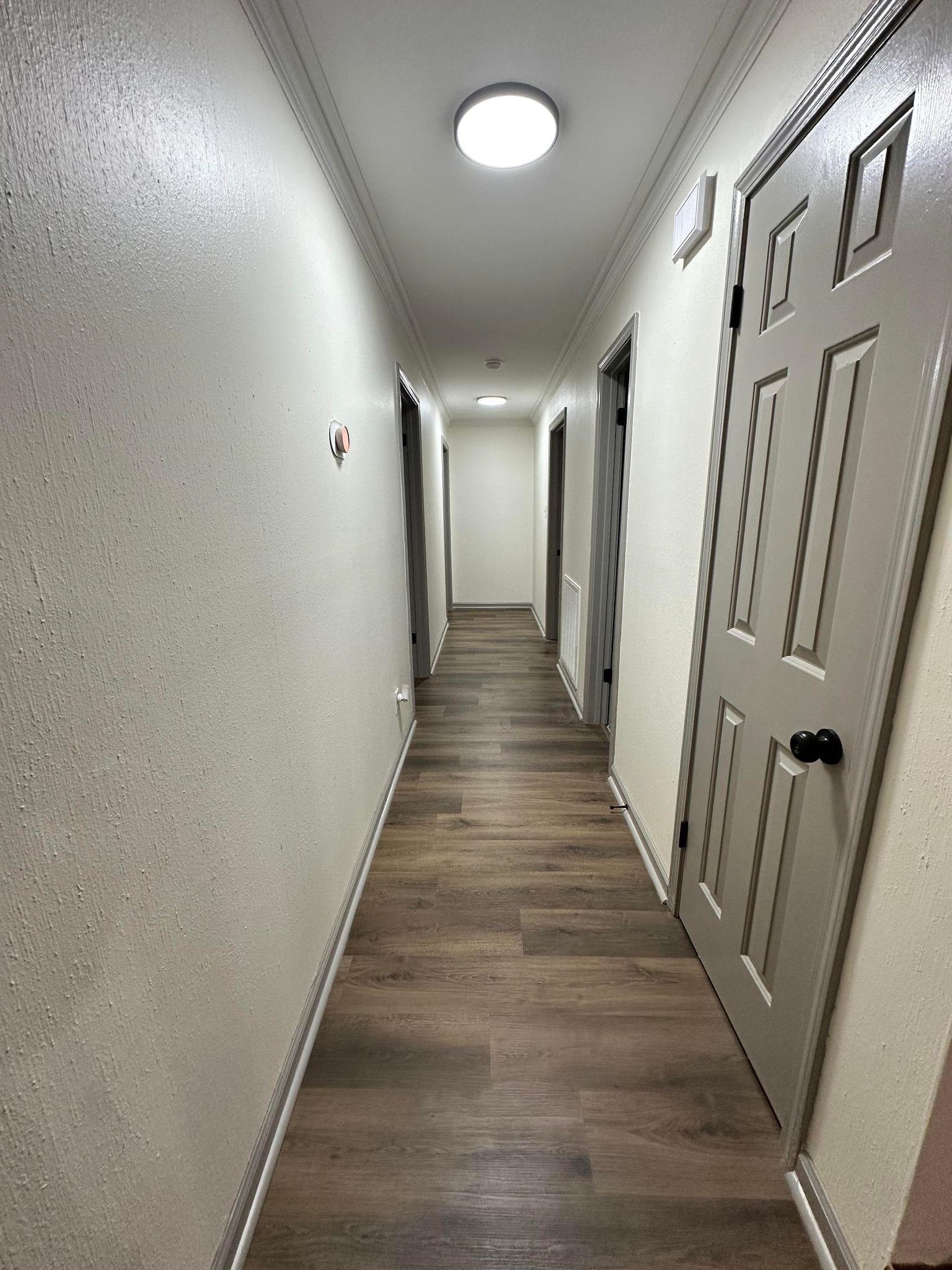 Hallway featuring dark hardwood / wood-style flooring and crown molding