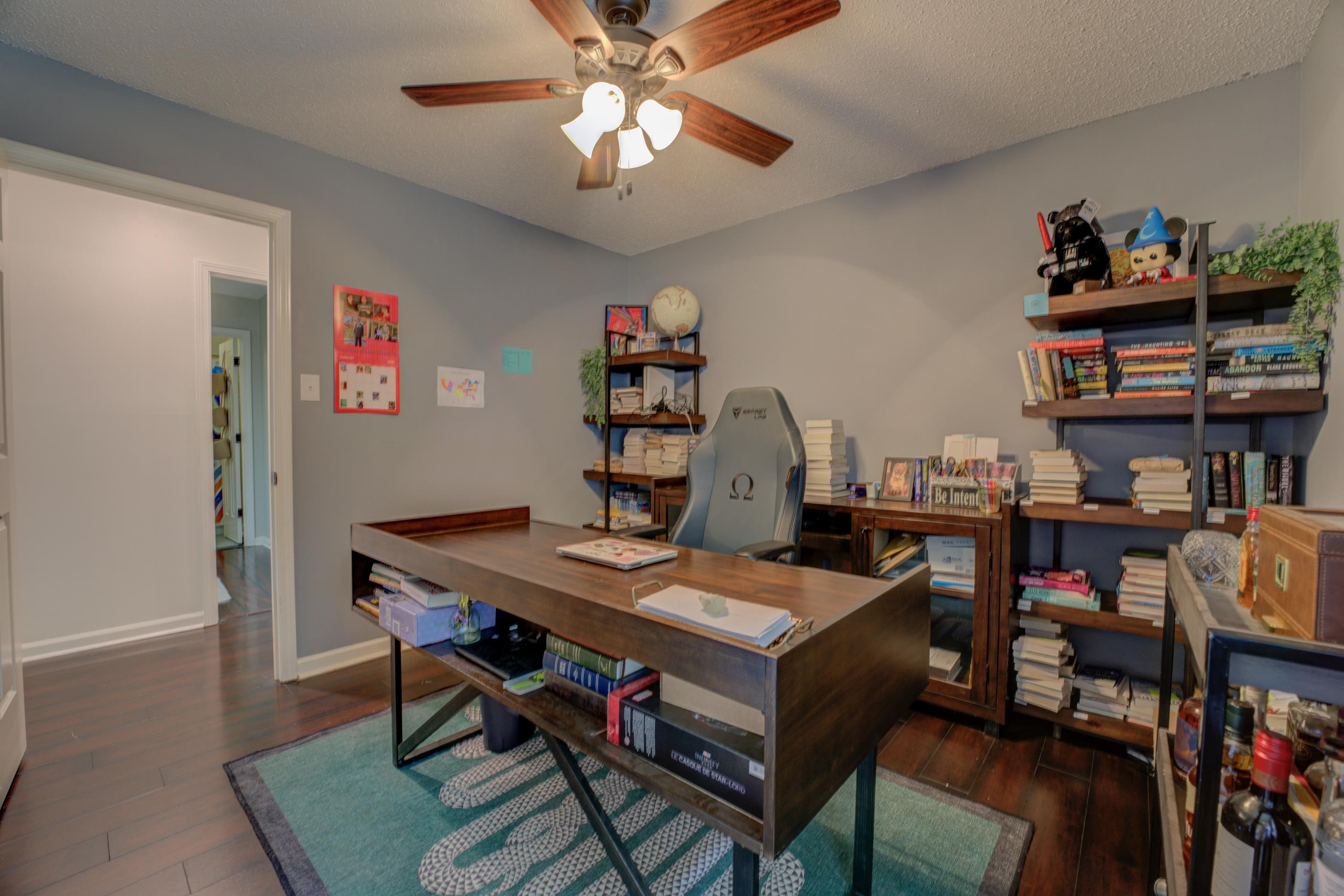 Office with a textured ceiling, ceiling fan, and dark hardwood / wood-style floors