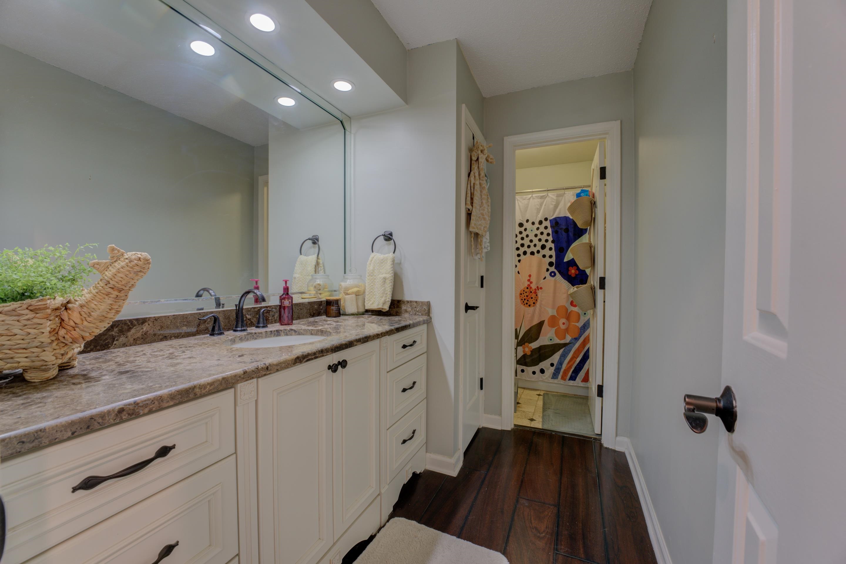 Bathroom with vanity, wood-type flooring, and walk in shower