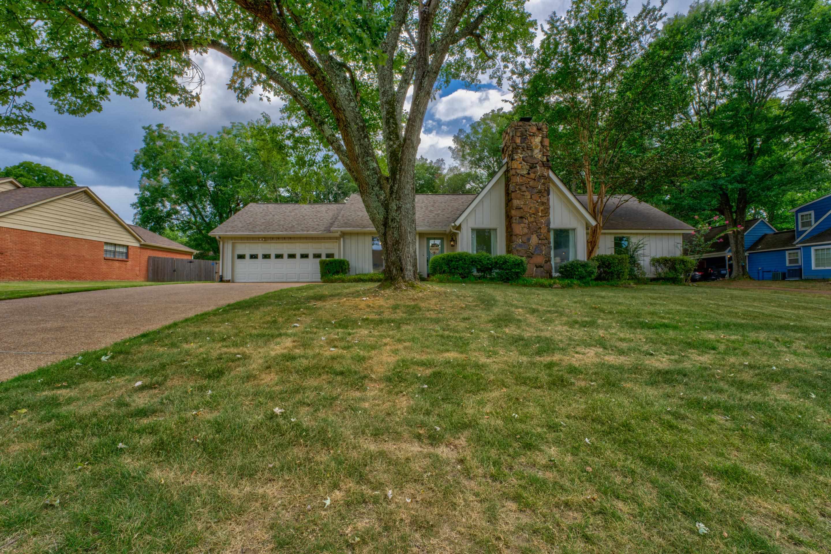 Ranch-style house with a front yard and a garage