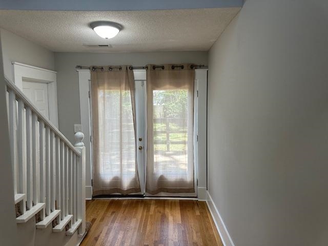 Doorway with hardwood / wood-style flooring and a textured ceiling