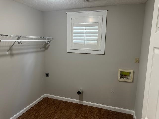 Washroom featuring a textured ceiling, hookup for a washing machine, dark hardwood / wood-style flooring, and electric dryer hookup