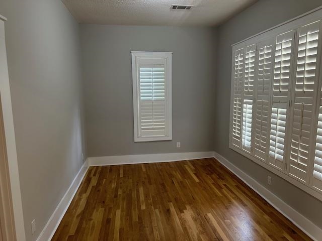 Unfurnished room featuring a textured ceiling and hardwood / wood-style flooring