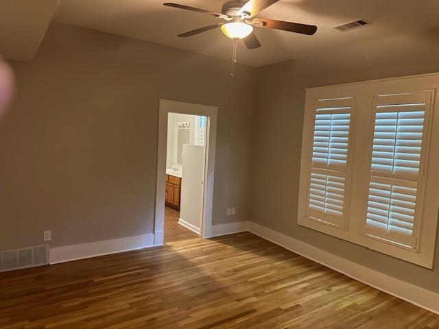 Empty room featuring hardwood / wood-style floors and ceiling fan