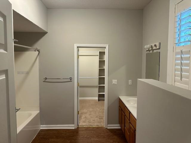 Bathroom featuring shower / bath combination, hardwood / wood-style flooring, and vanity