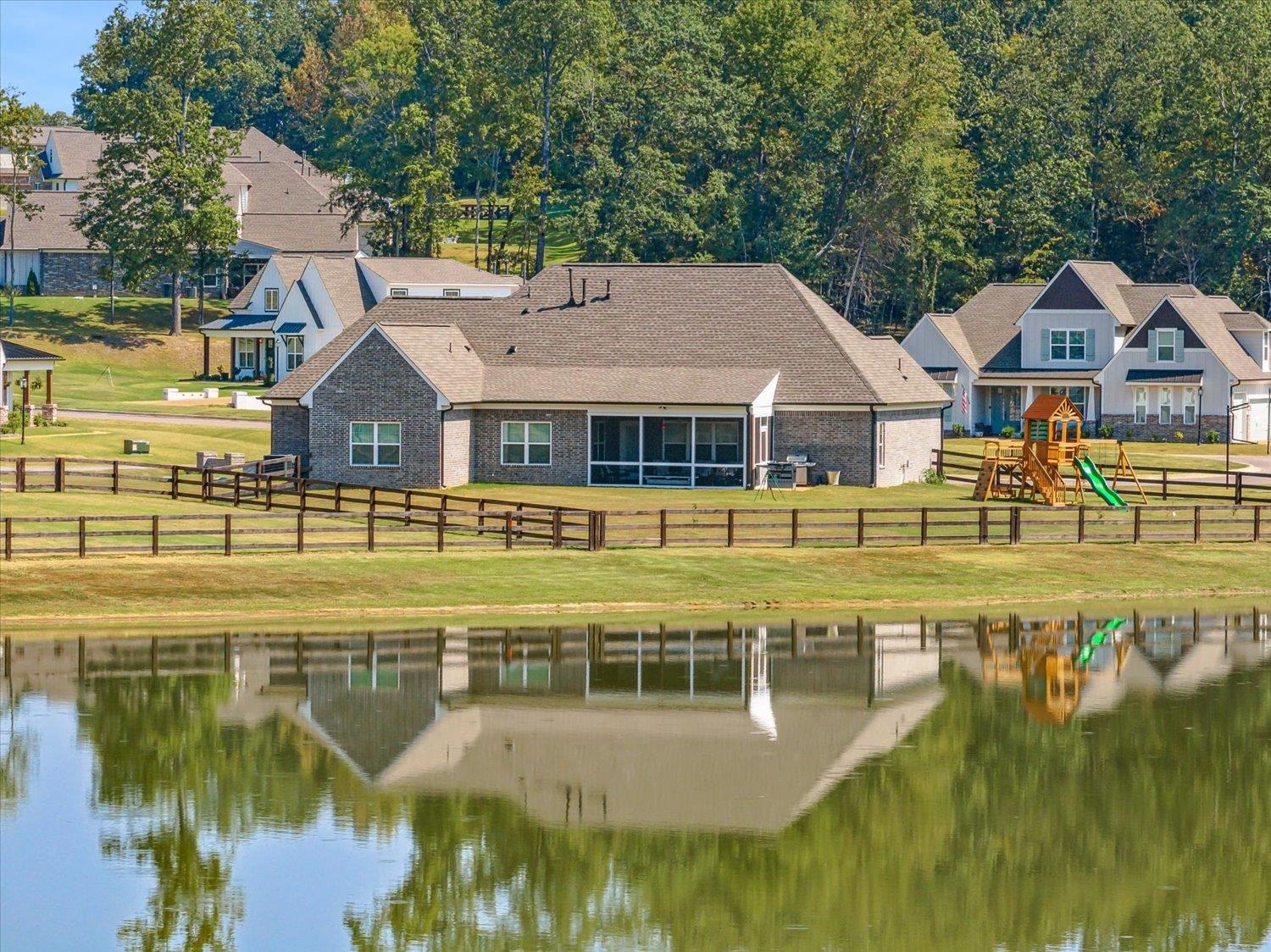 Exterior space featuring a playground, a water view, and a yard