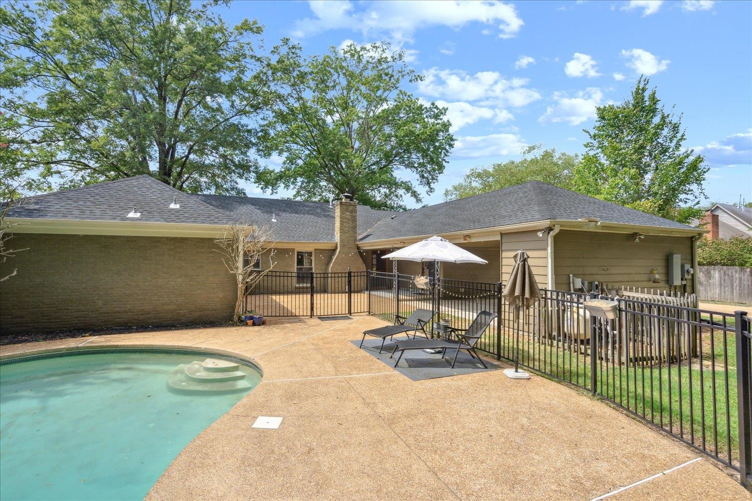 View of pool with a patio area and a lawn